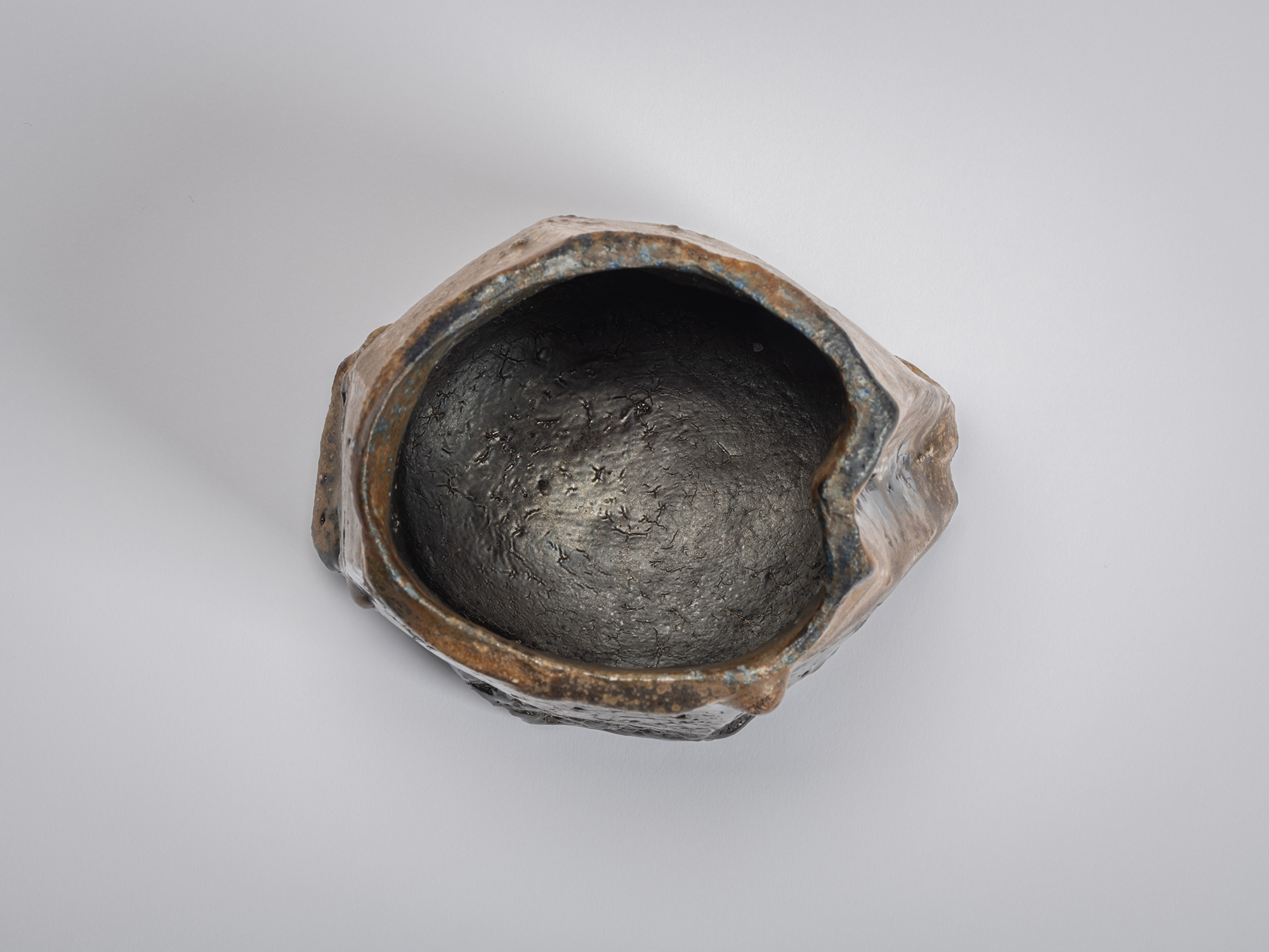 Aerial interior view of a black tea bowl by Ryuichi Kakurezaki showing a deep rounded interior...