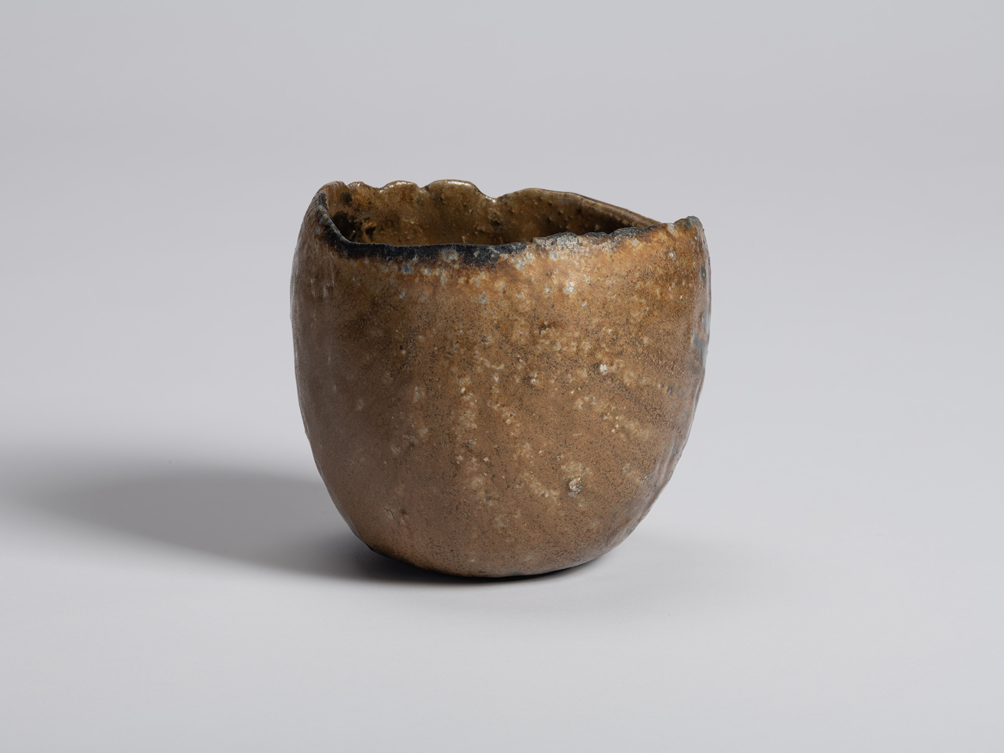 Black tea bowl by Ryuichi Kakurezaki with a pale brown clay surface and softly rounded form. Fine...