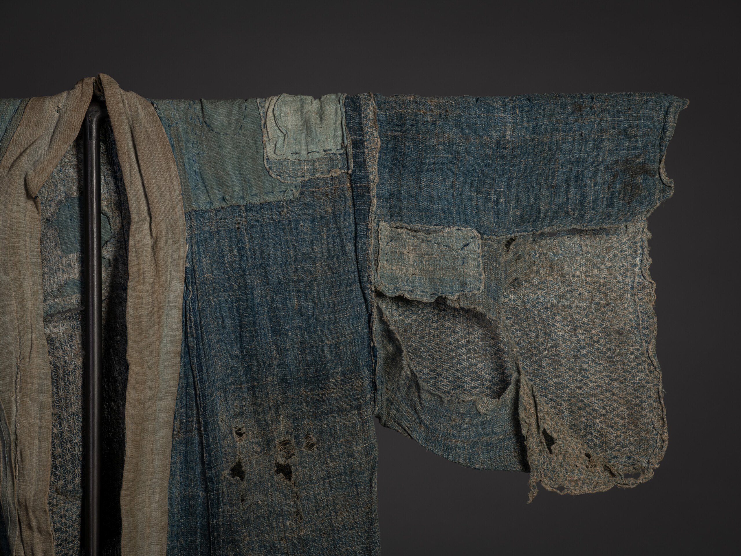 Close-up of the kimono's right sleeve and upper torso. The sleeve is heavily worn with large losses,...
