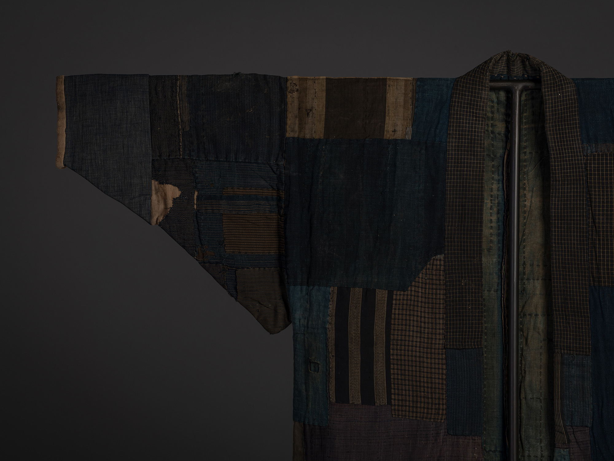 Close-up of the shoulder and sleeve of a Japanese boro kimono composed of indigo-blue, brown, and...