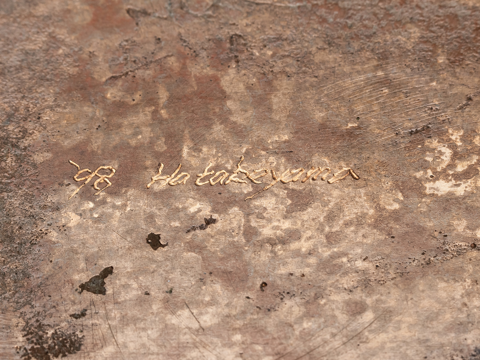 Close-up of the underside of Koji Hatakeyama’s Bronze Box showing the artist’s incised signature...