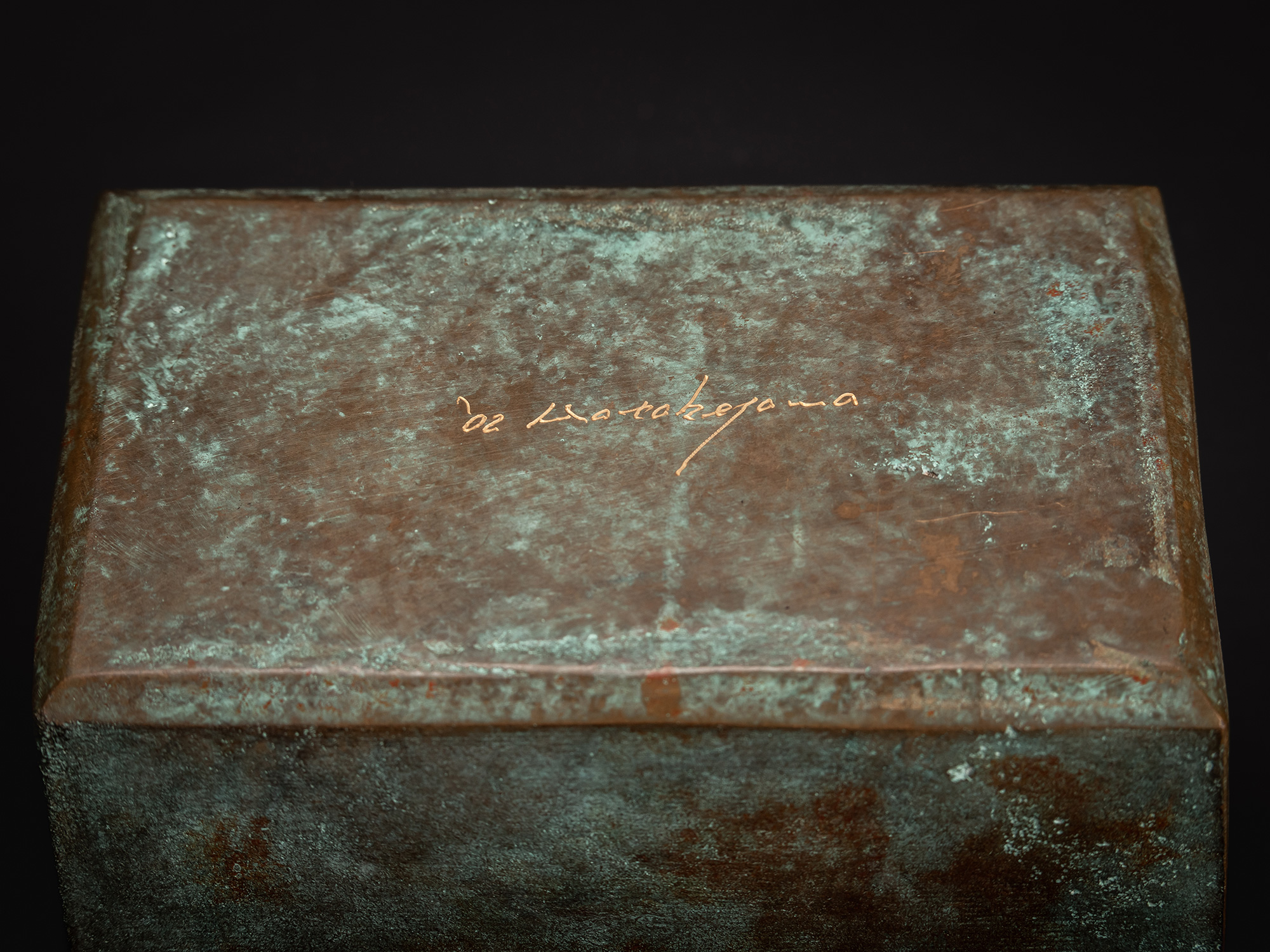 Close-up of the underside of the Bronze Box showing Koji Hatakeyama’s incised signature and date....