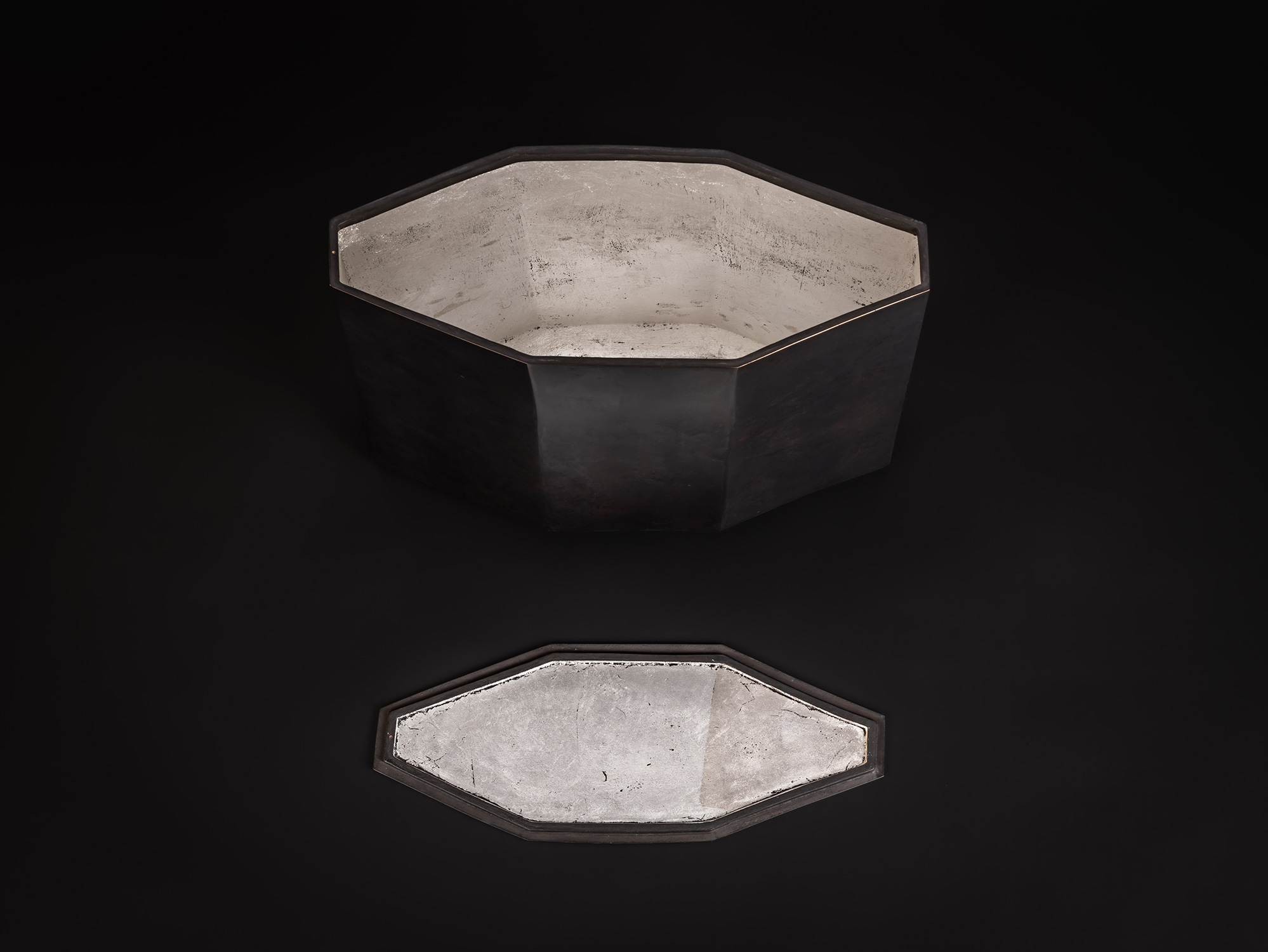 Eight Faces by Koji Hatakeyama shown with its lid removed and placed in front of the vessel, revealing...