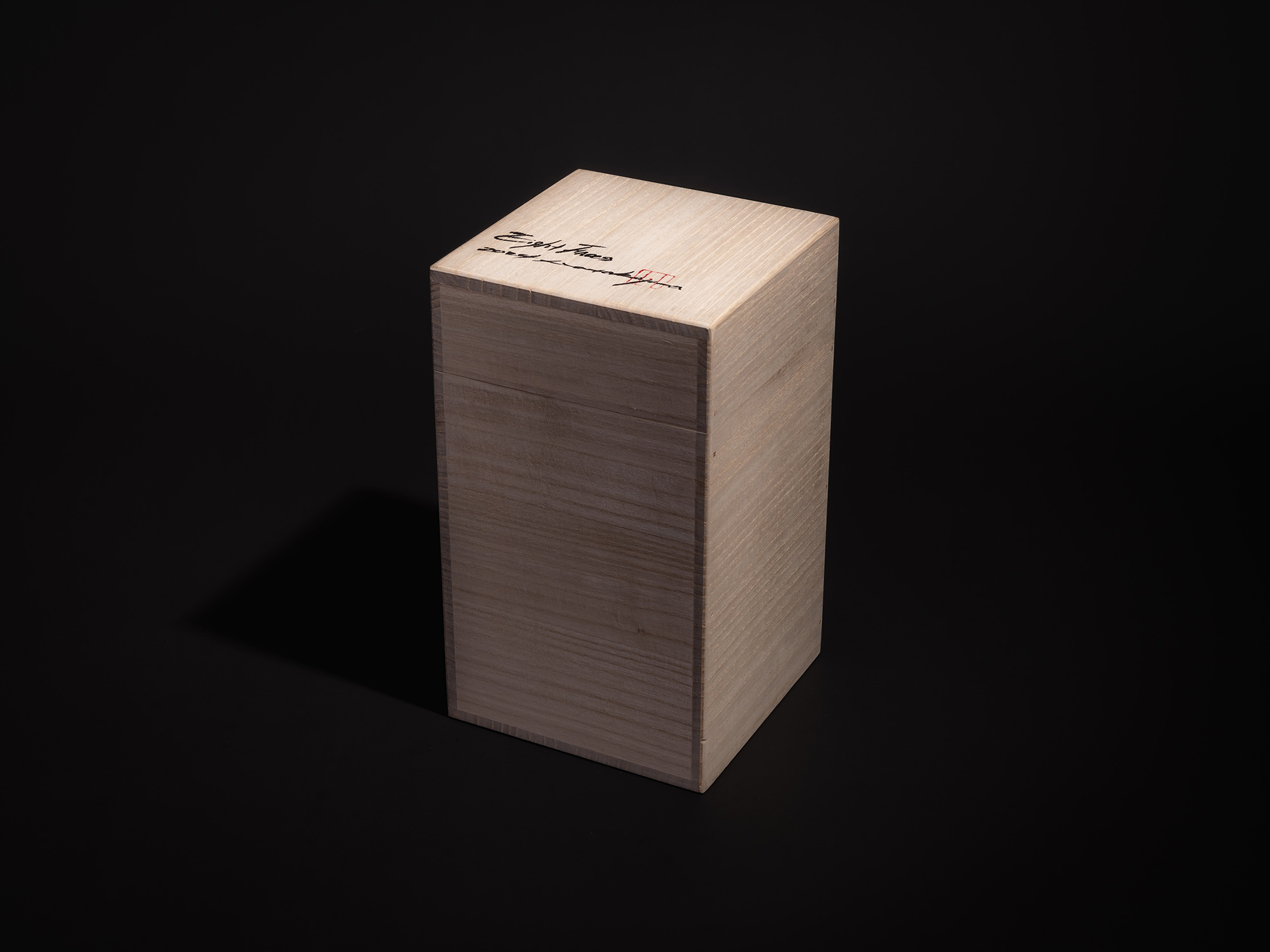 Three-quarter view of the tomobako for Eight Faces XVI by Koji Hatakeyama, showing a tall light...