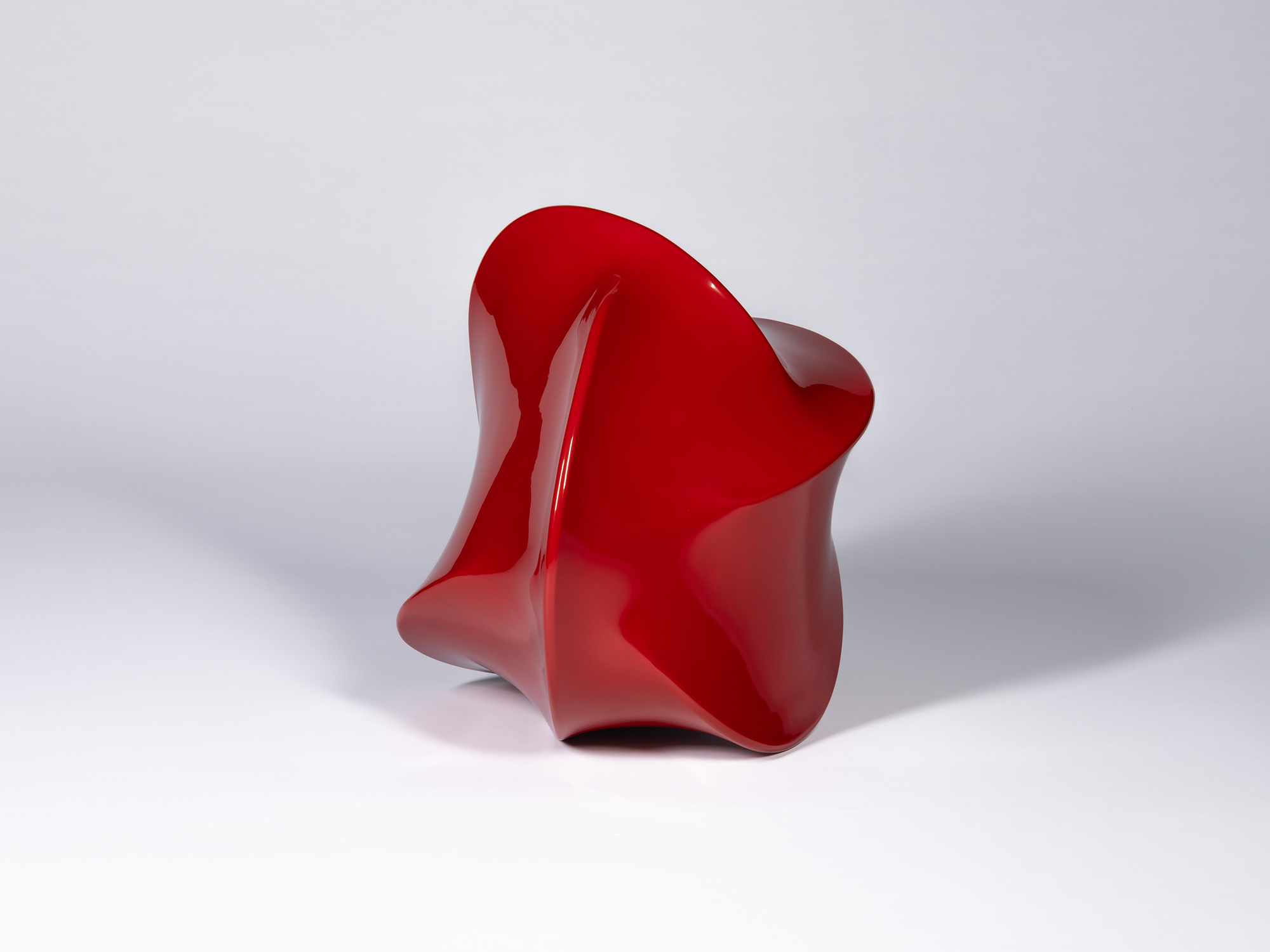 Deep red urushi lacquer sculpture by Genta Ishizuka with a smooth, flowing, asymmetrical form,...