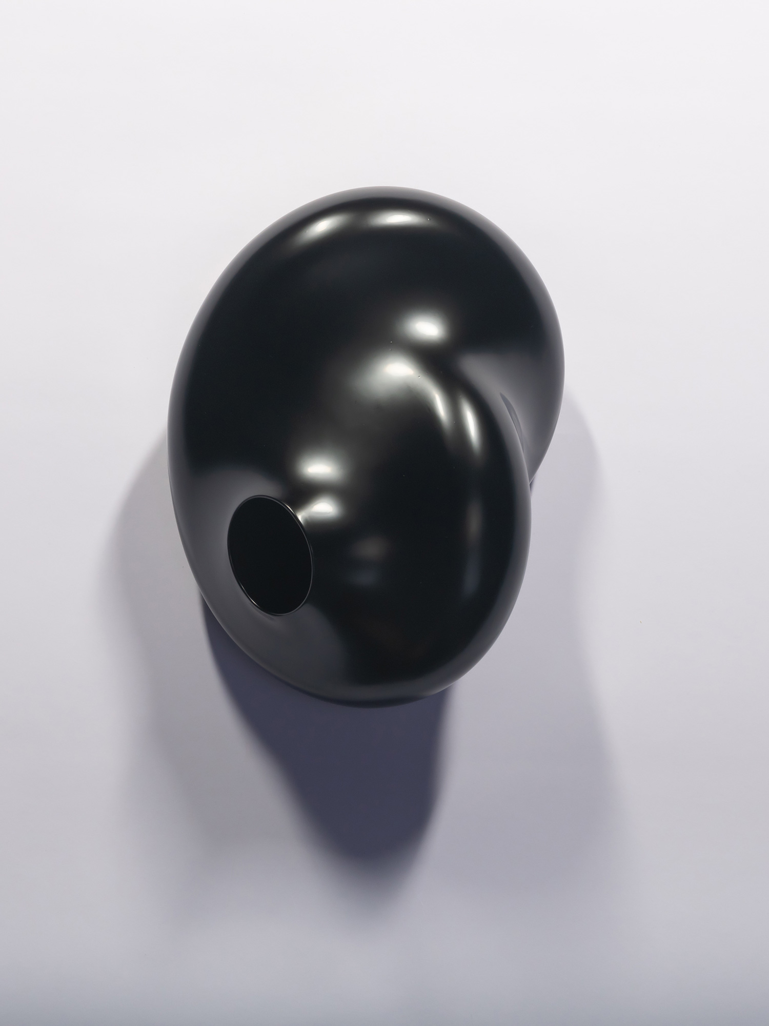 A wall-mounted, glossy black lacquer sculpture titled Membrane Spot by Genta Ishizuka. The artwork...