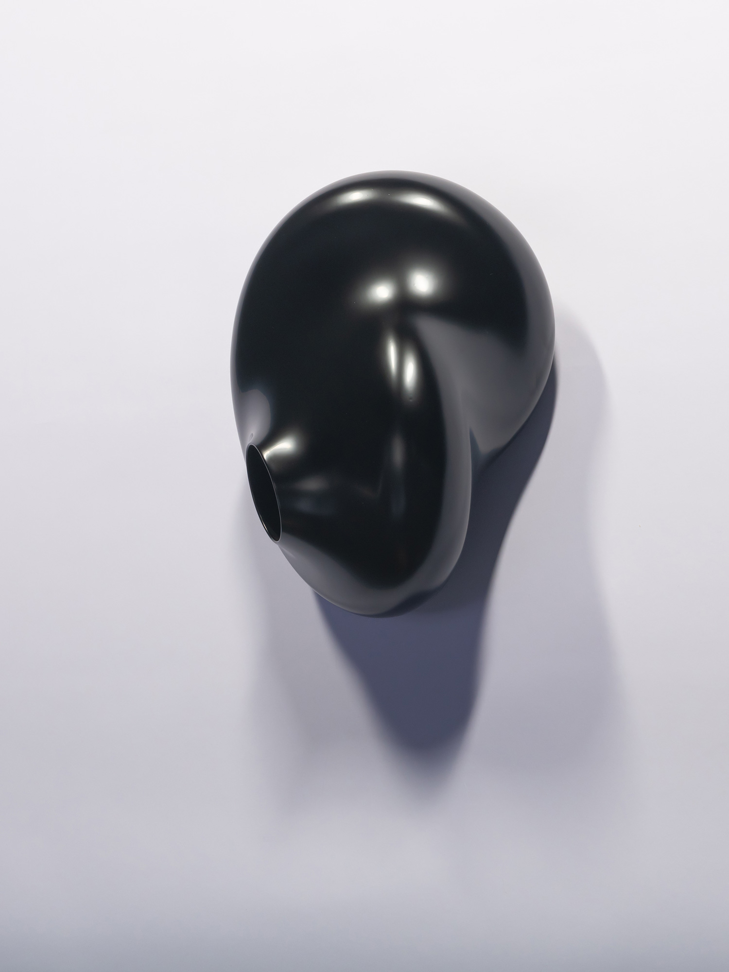 A wall-mounted, glossy black lacquer sculpture titled Membrane Spot by Genta Ishizuka. The artwork...