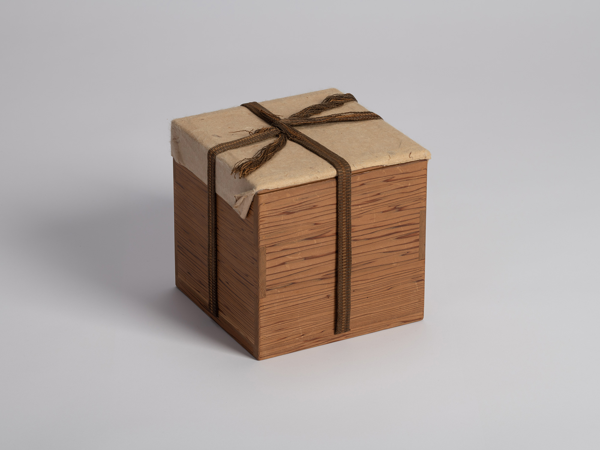 A square paulownia wooden storage box (tomobako) used for housing a historic Raku tea bowl attributed...