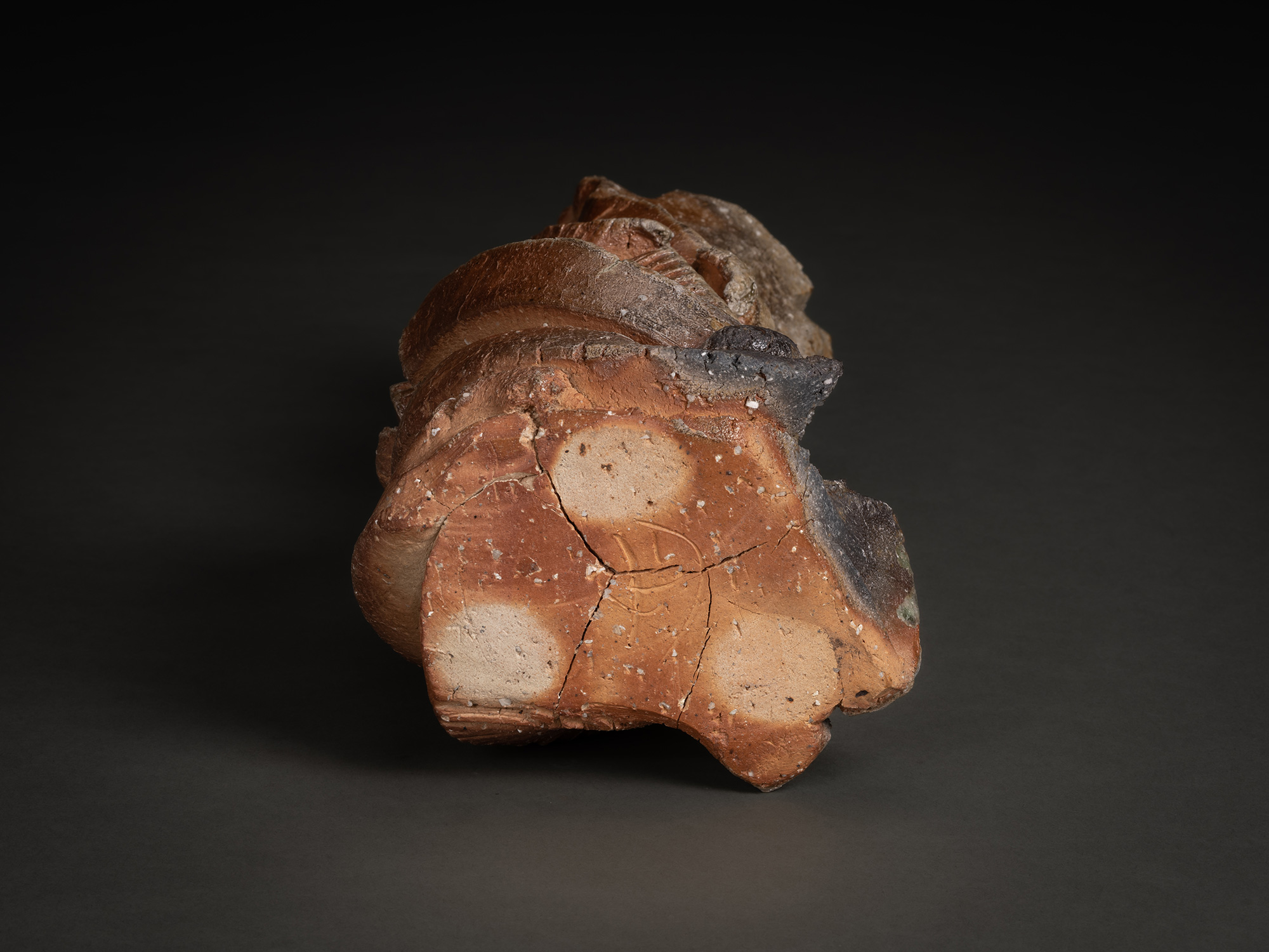 Foot of a natural ash sculptural form by Shōzō Michikawa showing an irregular unglazed clay base...