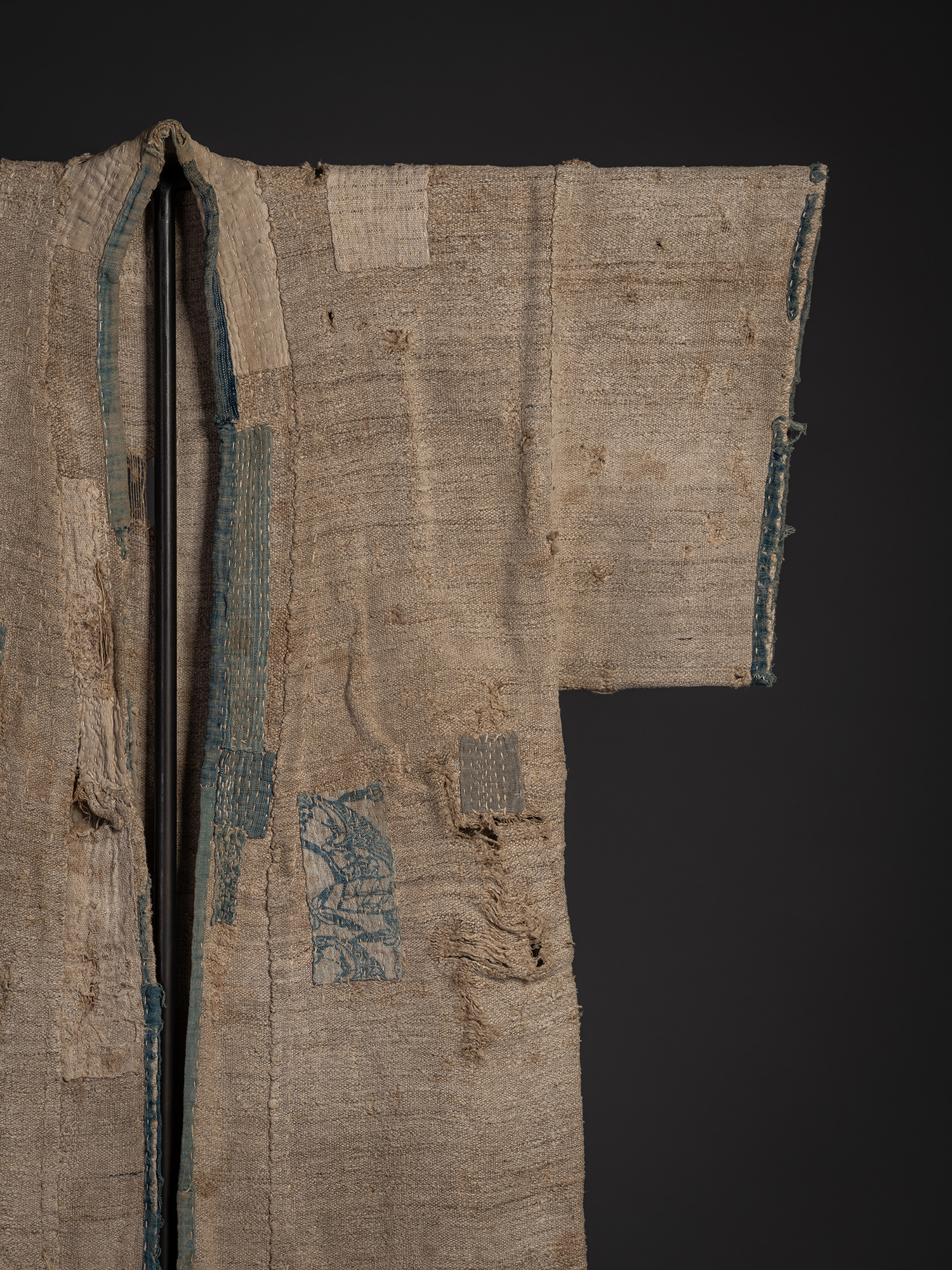 Detail of the upper right front of a late 19th-century okusozakkuri garment showing patched repairs...