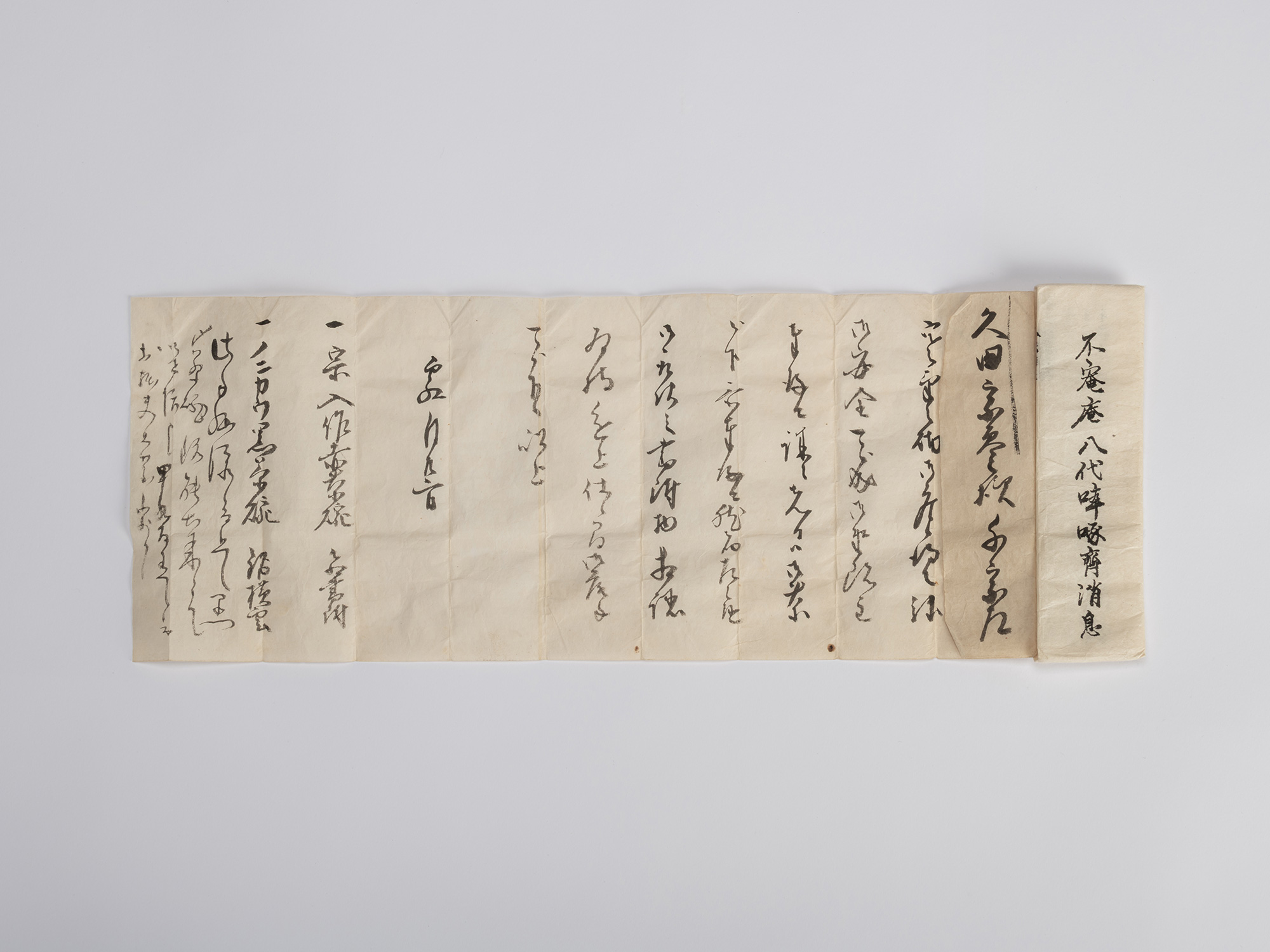 An unrolled, horizontally oriented hand-scroll or accordion-folded document (kanshōgaki) of aged,...