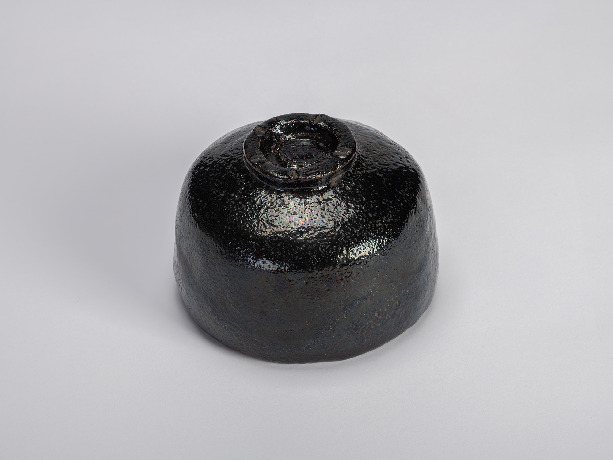 Underside three-quarter view of the black Raku tea bowl Yokogumo (“Horizontal Clouds”) by Raku...