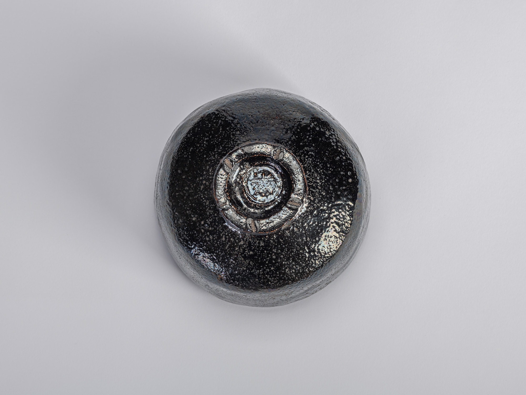 Underside view of the black Raku tea bowl Yokogumo (“Horizontal Clouds”) by Raku Dōnyū. The bowl...