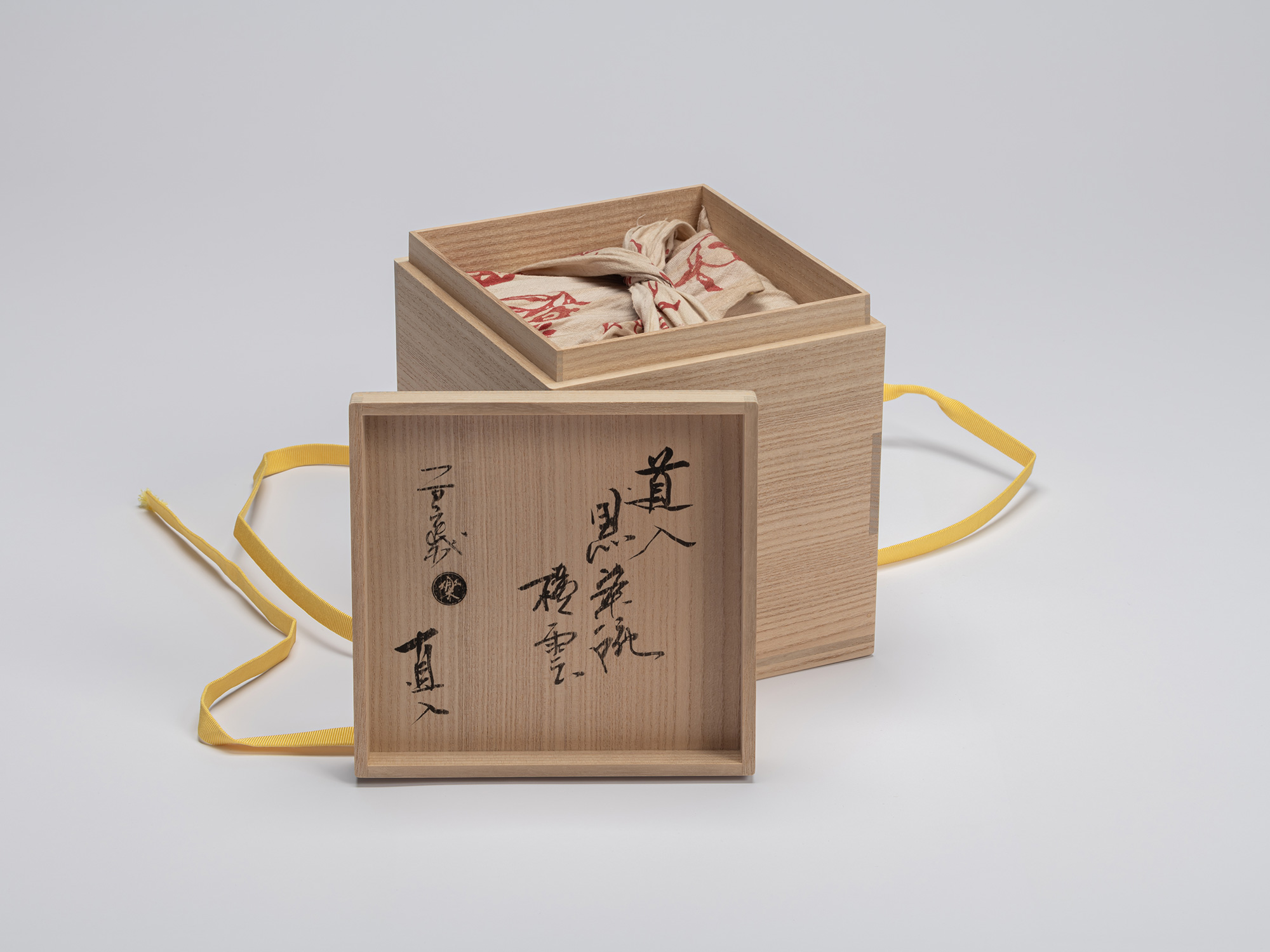 The open, light-colored paulownia wood innermost storage box (tomobako) for the Yokogumo tea bowl...