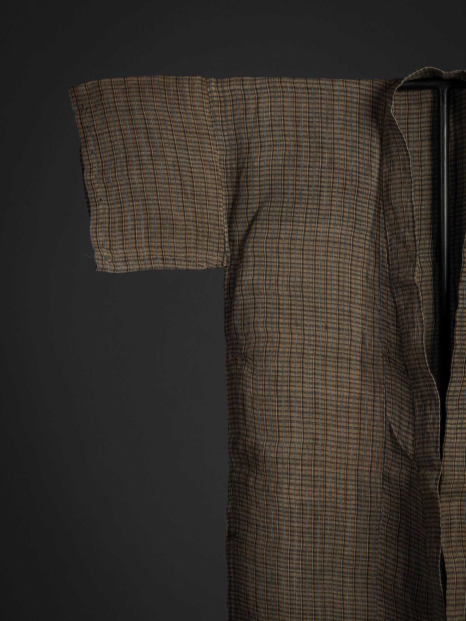 Close-up of the upper right front section of the kimono. The woven plaid pattern remains consistent...