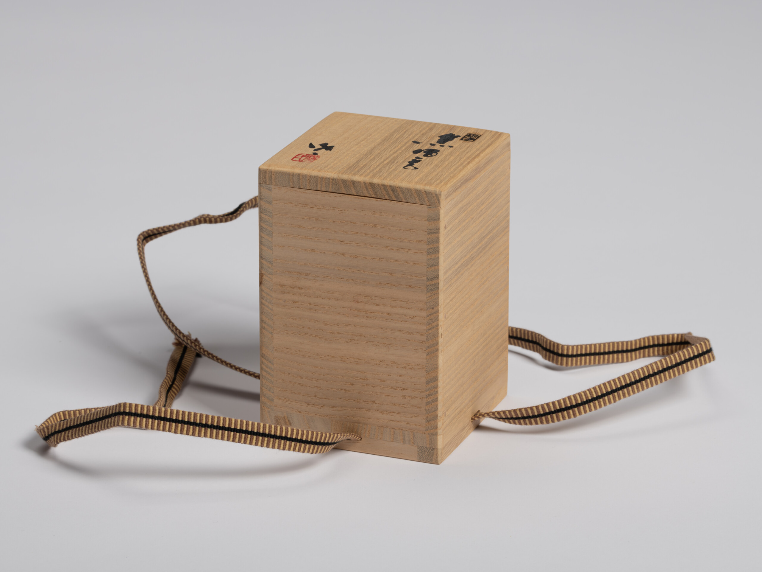 Three-quarter view of the paulownia wood (tomobako) for Ryuichi Kakurezaki's Black Guinomi. The...