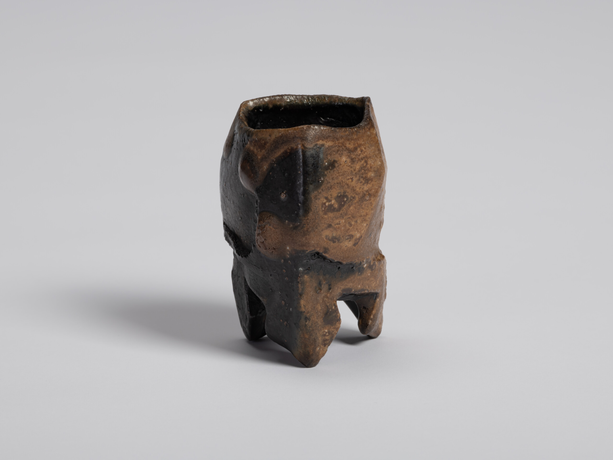 View from the opposite side showing the guinomi's faceted body and irregular square rim. Glossy...