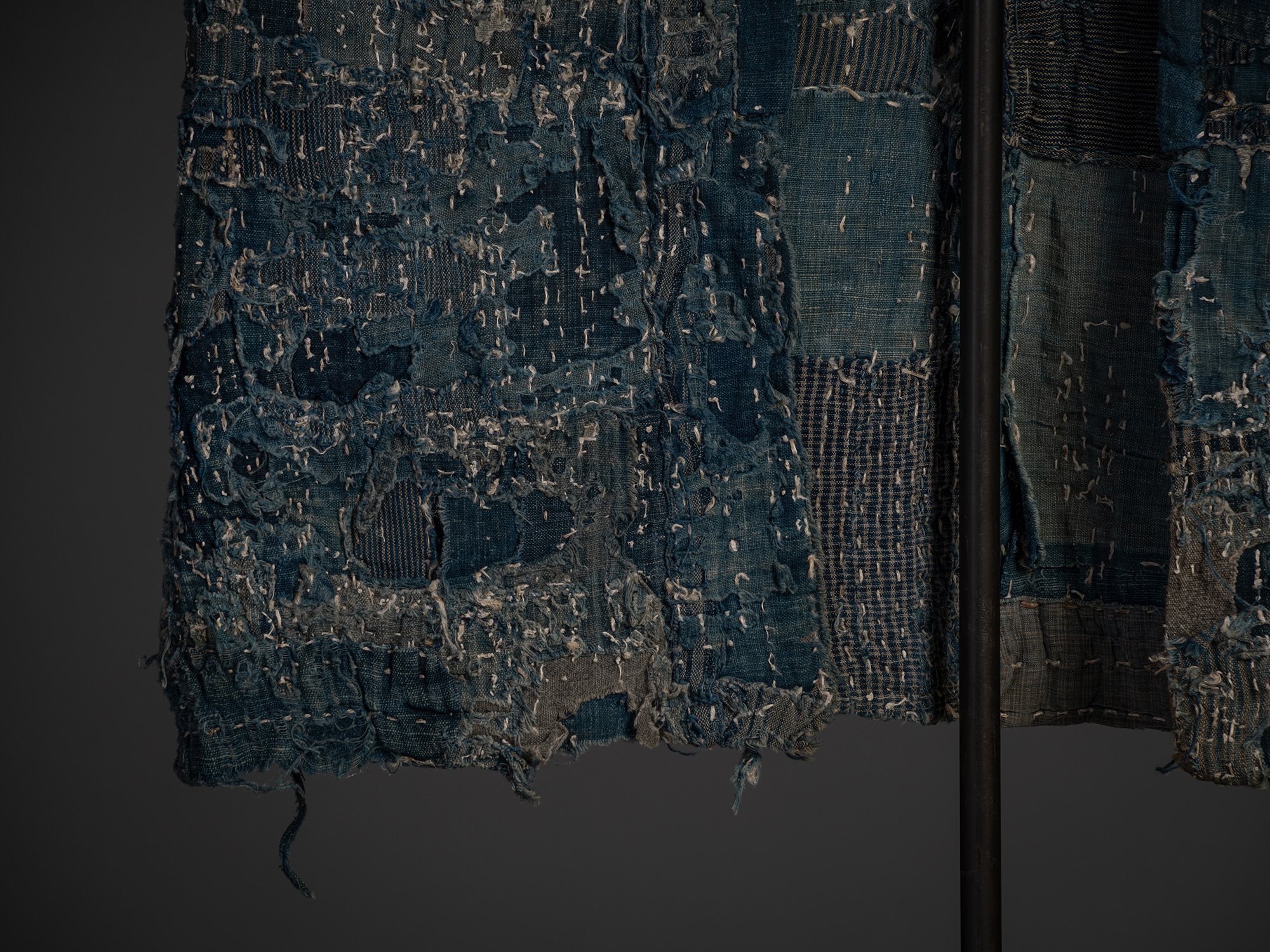Close-up of the lower front portion of the boro work coat. A dense arrangement of patched cotton...