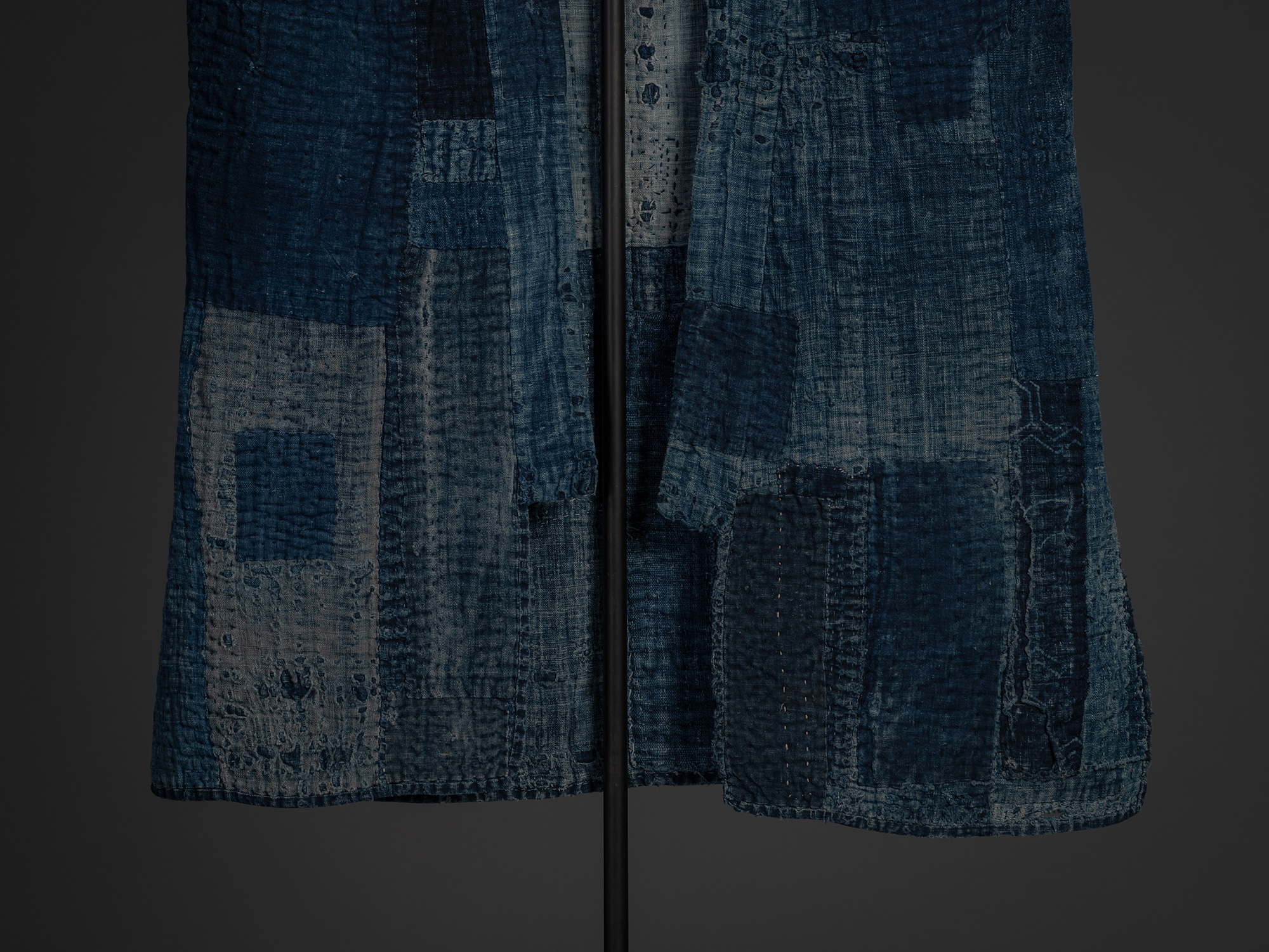 Close-up of the lower front of the Japanese boro work coat, showing the open front panels draped...