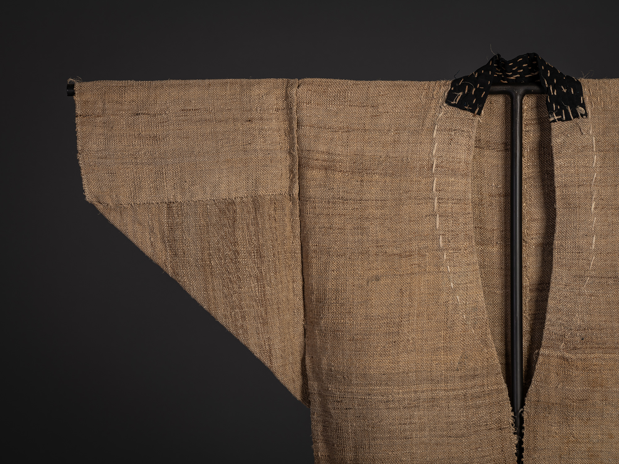 Close-up of the left shoulder and sleeve of the fujifu robe, highlighting the coarse woven texture...