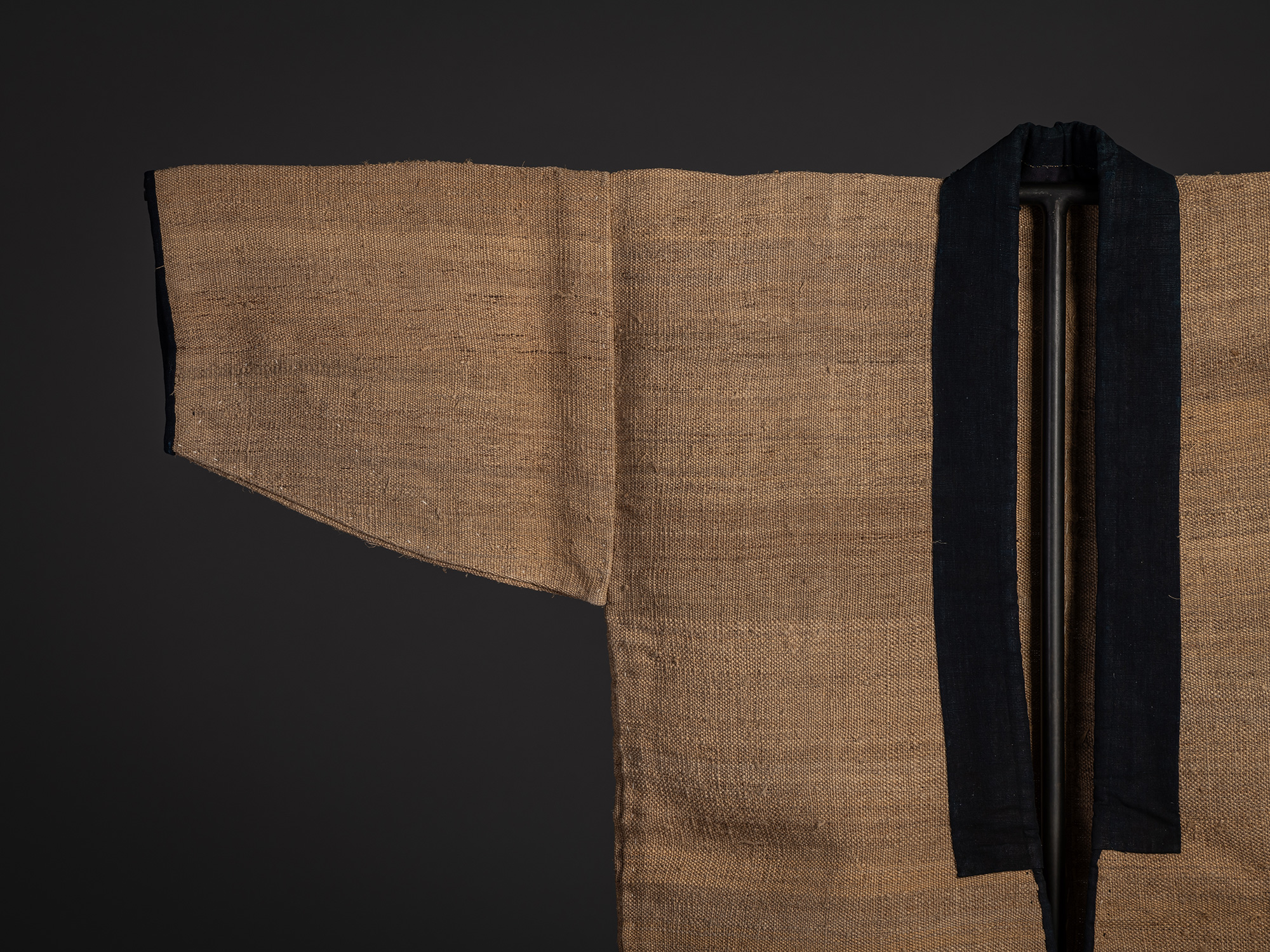 Close-up of the left right and sleeve of the fujifu work coat, highlighting the coarse, open weave...