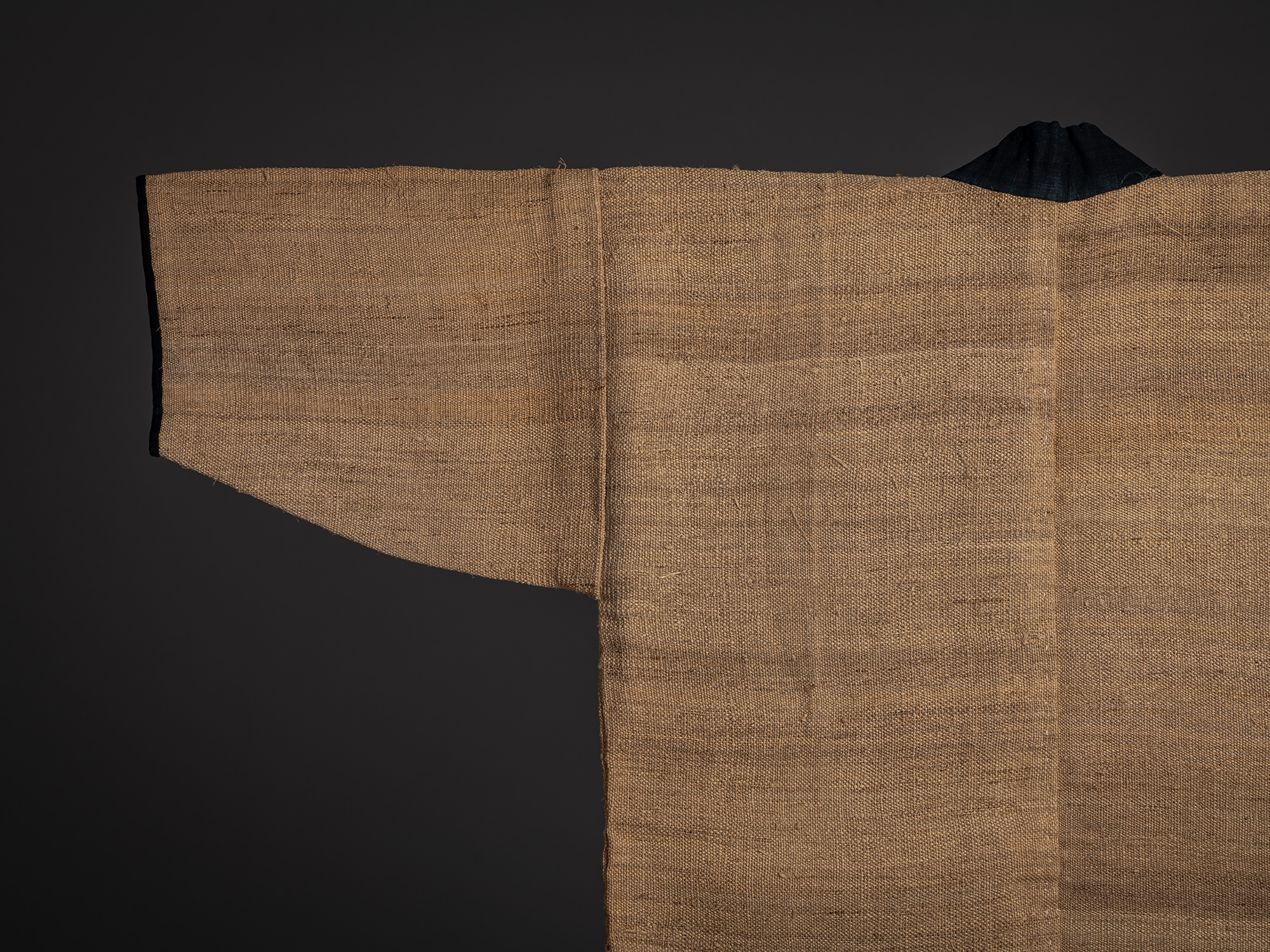 Close-up of the upper back and left sleeve of the fujifu work coat, showing the textured weave...