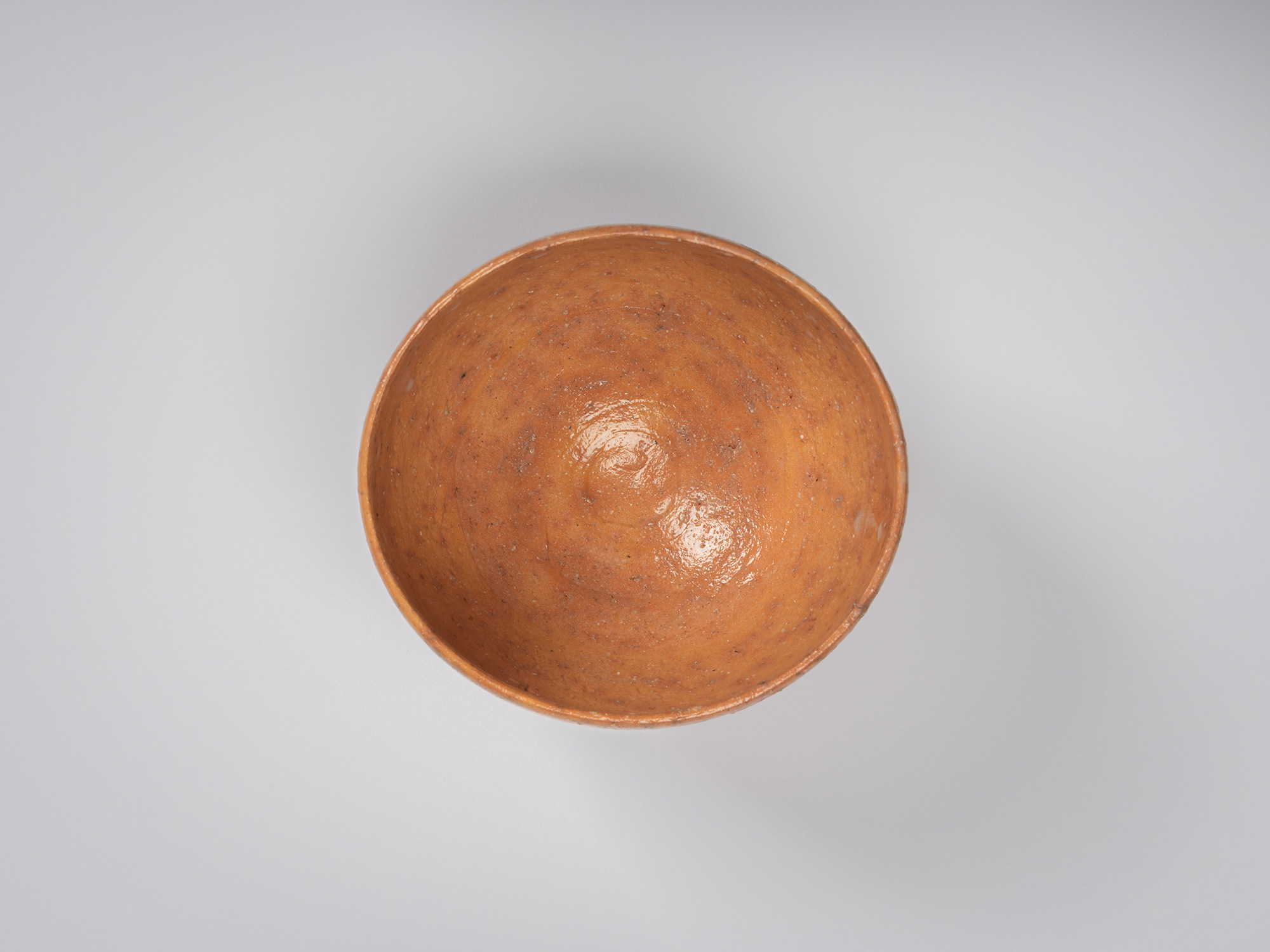 Overhead view of Goki Chawan revealing a deep, rounded interior coated in a glossy orange-brown...