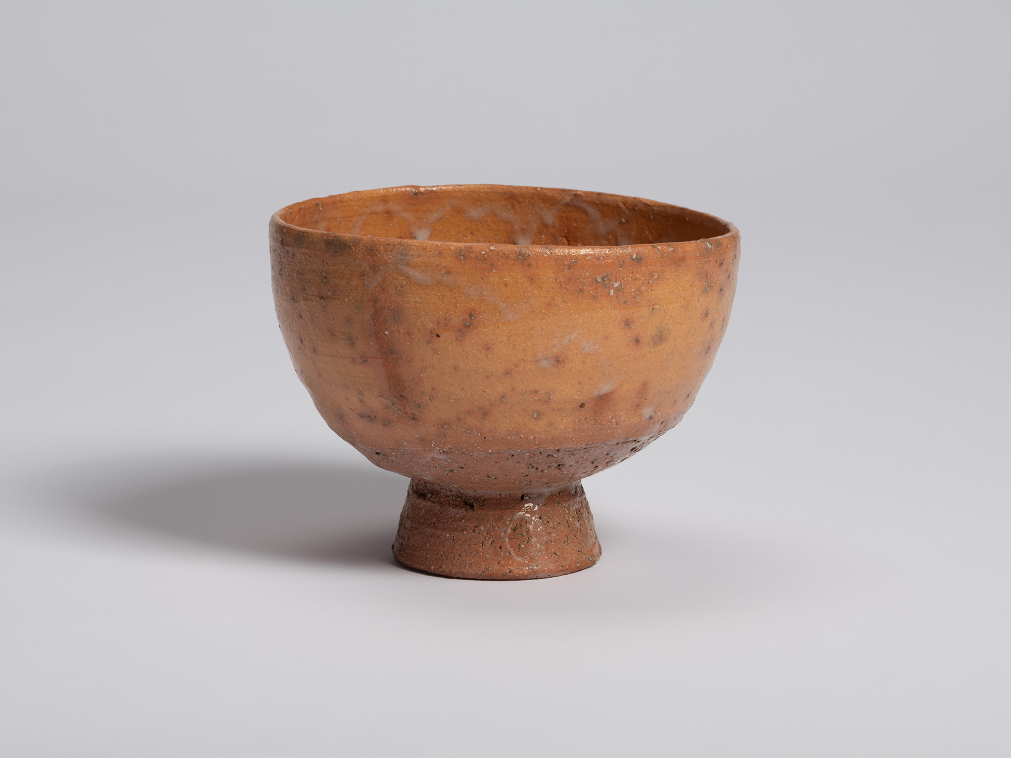 View of Goki Chawan showing its slightly asymmetrical profile and broad, open mouth. The orange-brown...