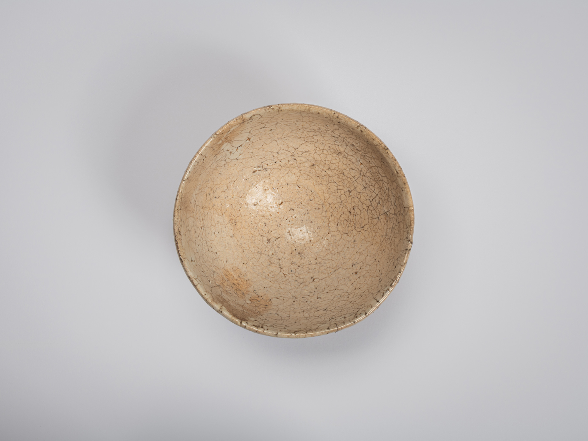 Aerial view of Ido Chawan revealing a wide, open interior. The bowl is coated in a soft ivory glaze...