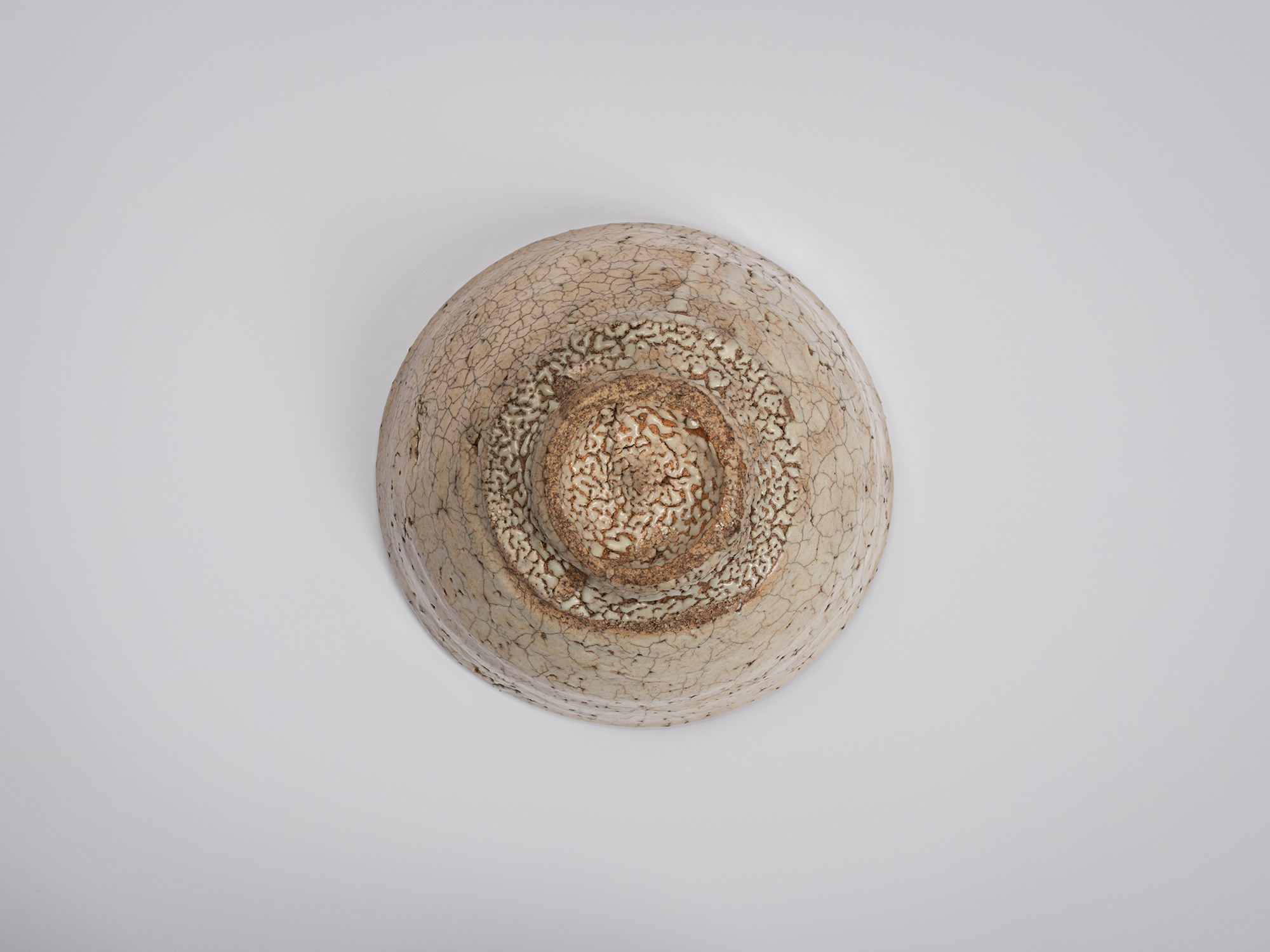 Direct underside view of Ido Chawan foot. The circular foot ring surrounds a recessed center with...