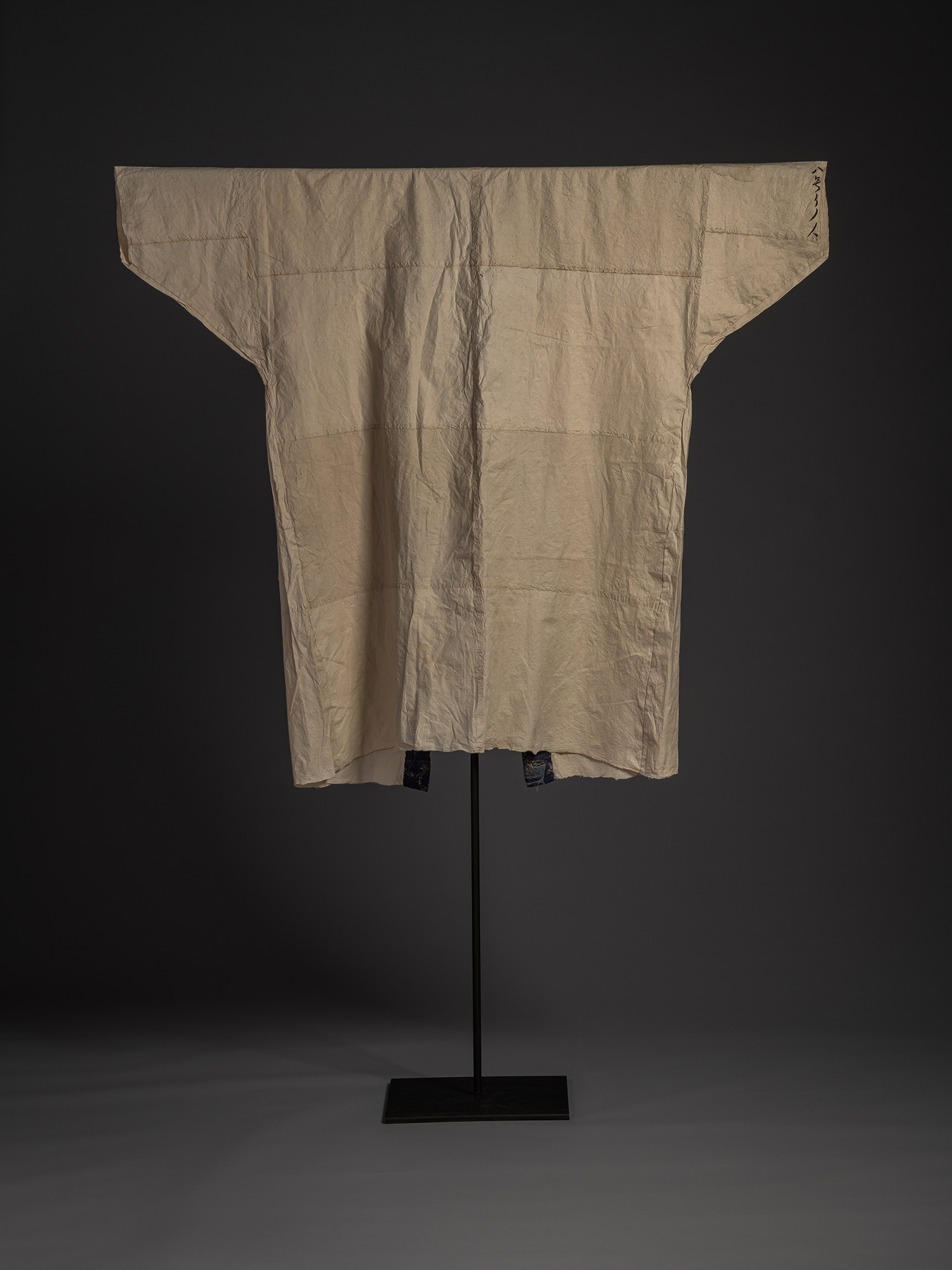Full back view of the kamiko surcoat showing its simple, geometric construction. The cream-colored...