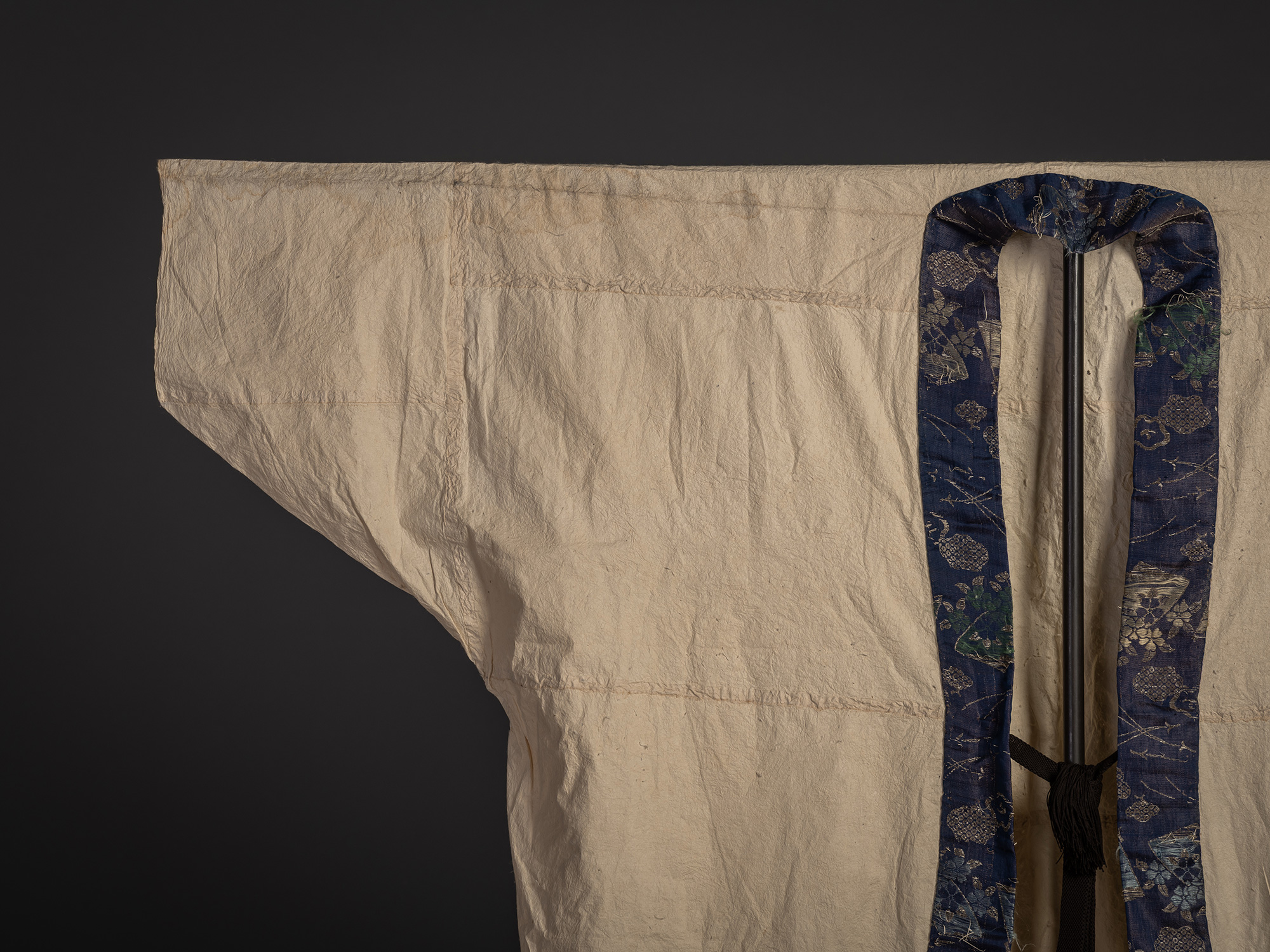 Close-up of the upper front section of the surcoat highlighting the contrast between the cream-colored...