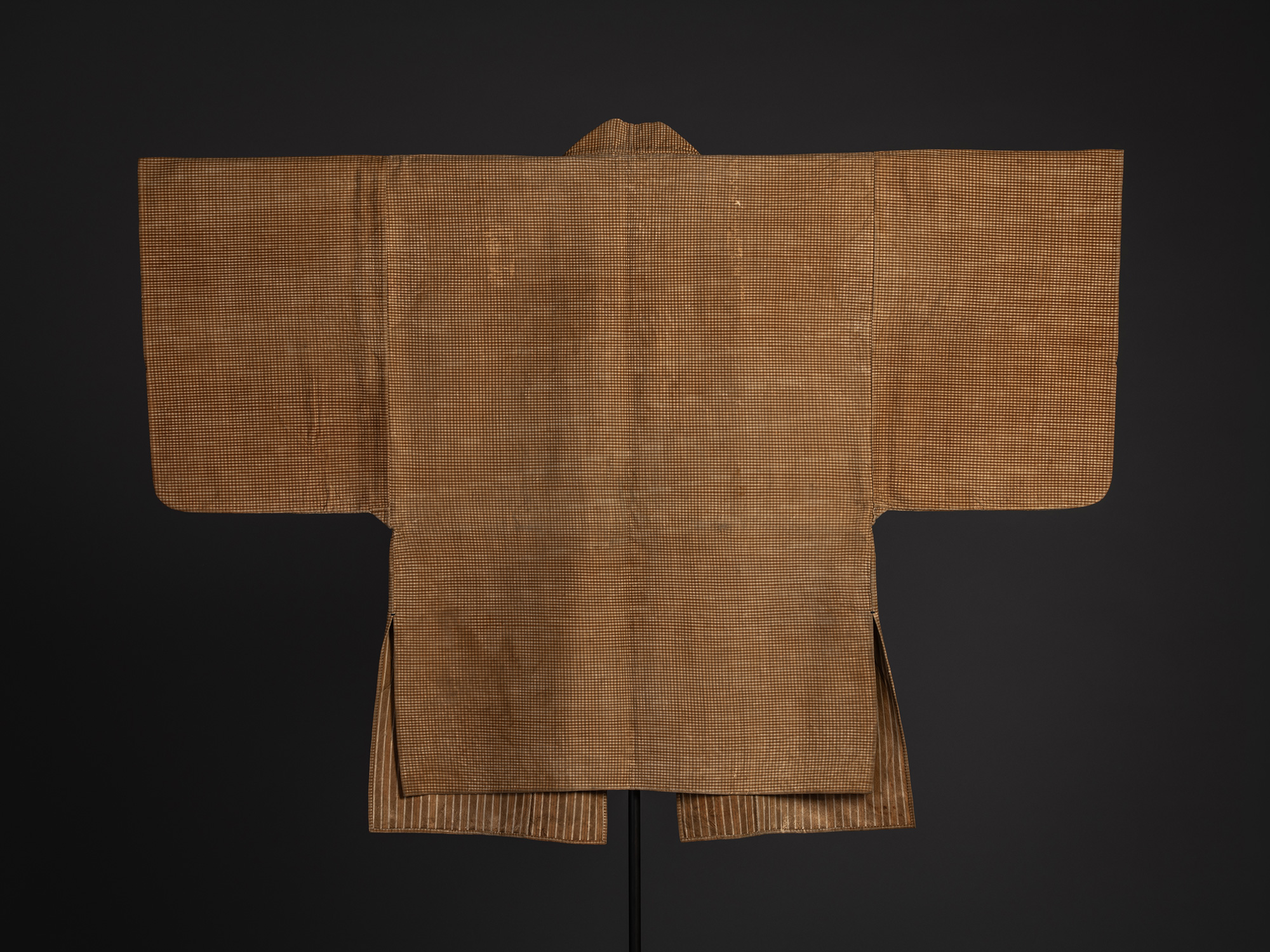 Full back view of a Japanese kawabaori displayed on a stand. The deerskin overcoat has wide sleeves,...