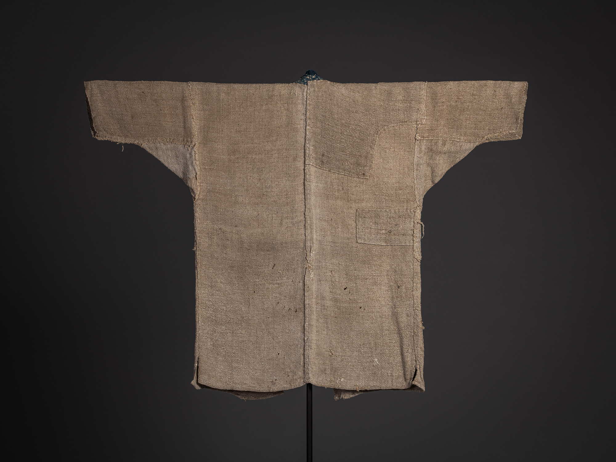 Full back view of an okusozakkuri work jacket woven from hemp and cotton, displayed on a stand....