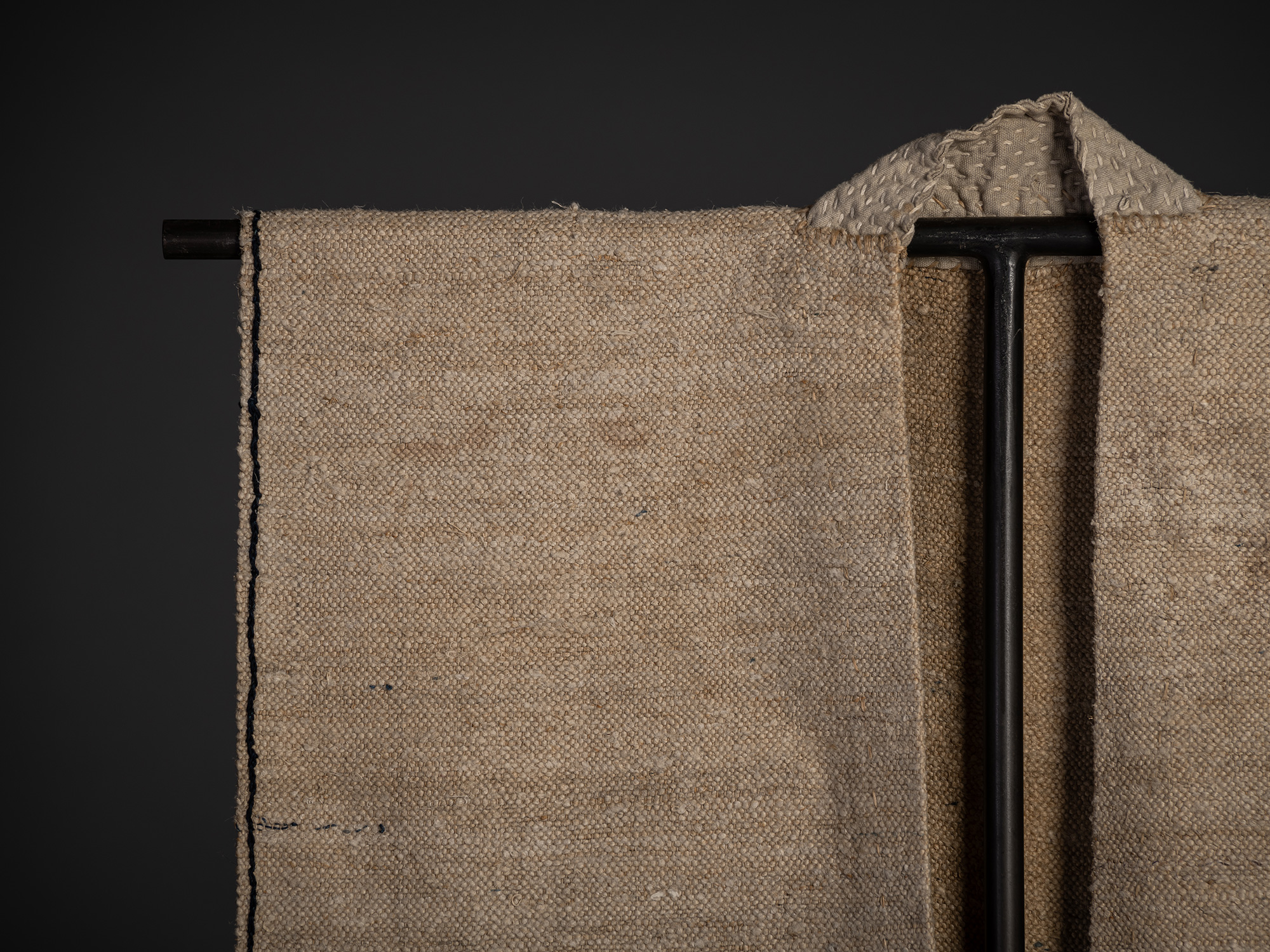 Close-up of the upper right front section of the garment. The folded collar reveals rows of white...