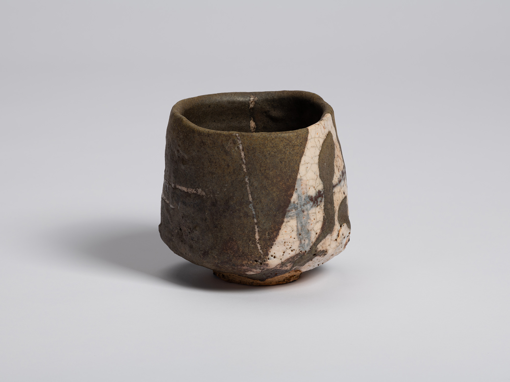 View of the tea bowl showing the transition between the dark exterior and the white glazed panel...