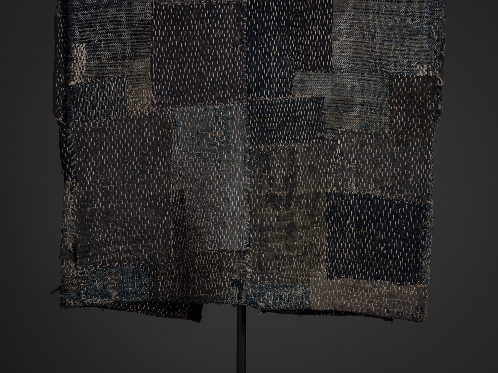 Close-up of the lower back of a Japanese sakiori boro work coat made of cotton and hemp. The patchwork...