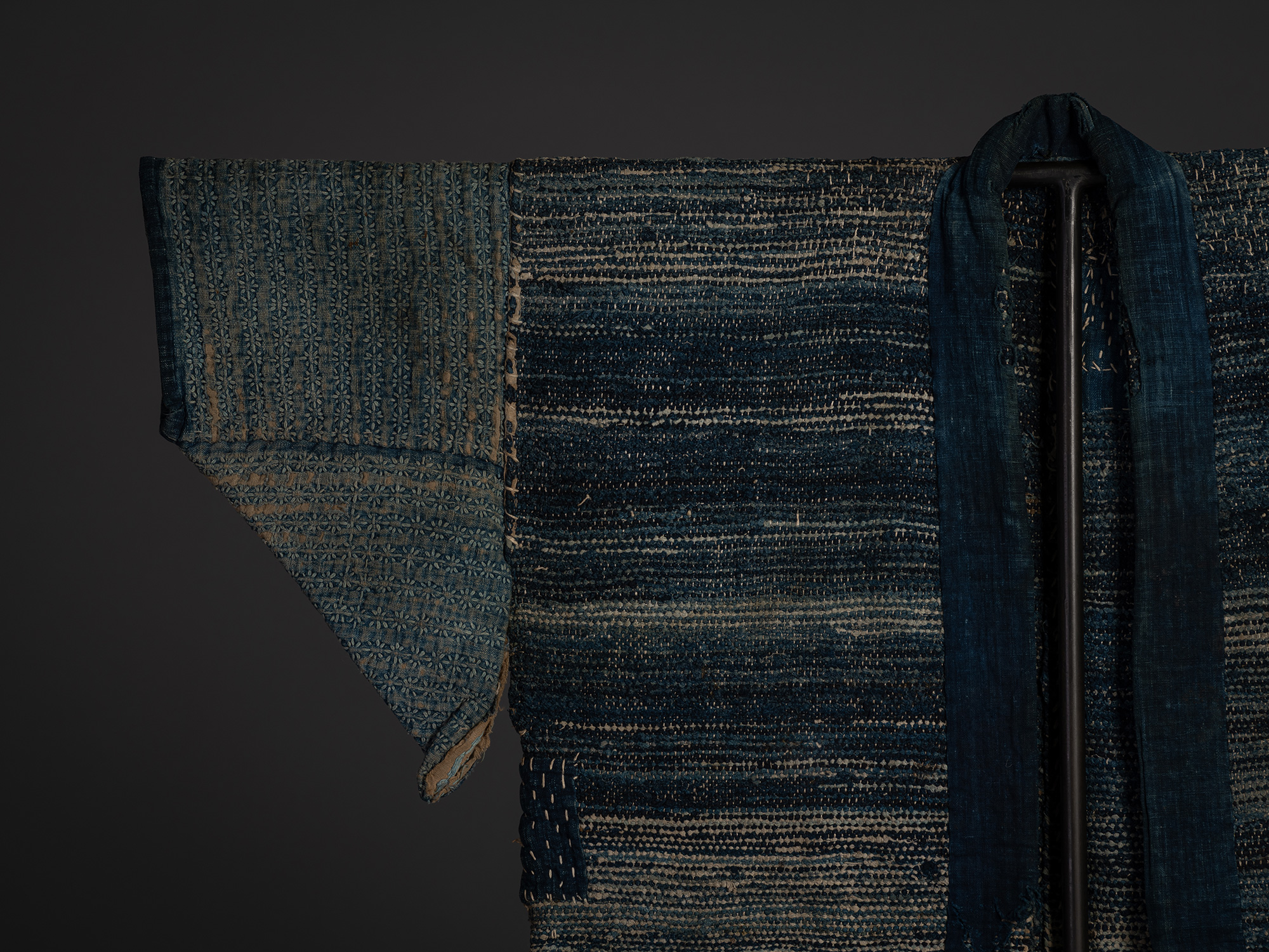 Close-up of the right sleeve, collar, and upper body of the indigo sakiori hanten. The long indigo...