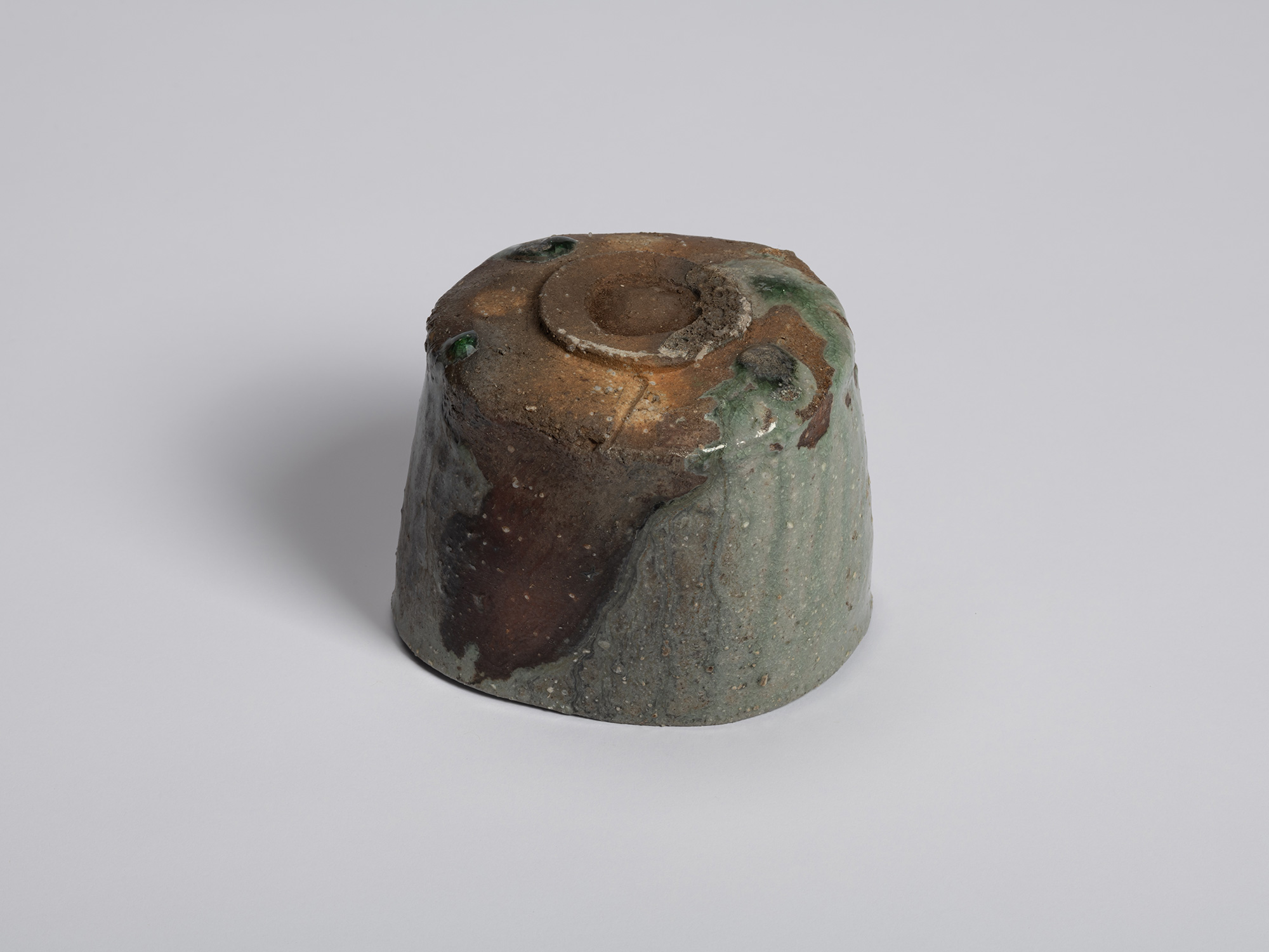 Underside view of the tea bowl showing the unglazed foot ring and warm brown clay body. Traces...
