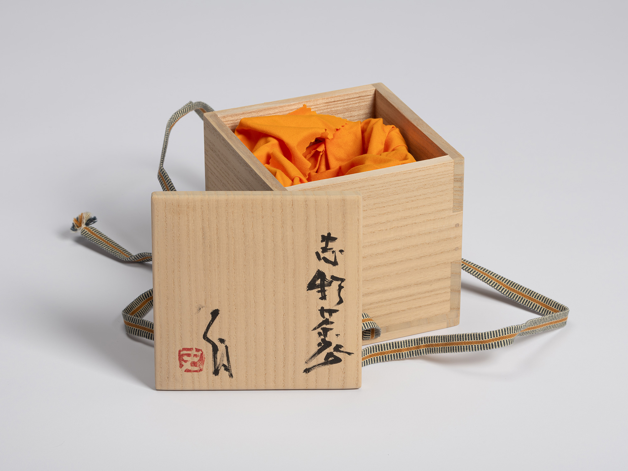 Tomobako for a Shino Chawan by Shiro Tsujimura shown with the lid removed and placed in front of...