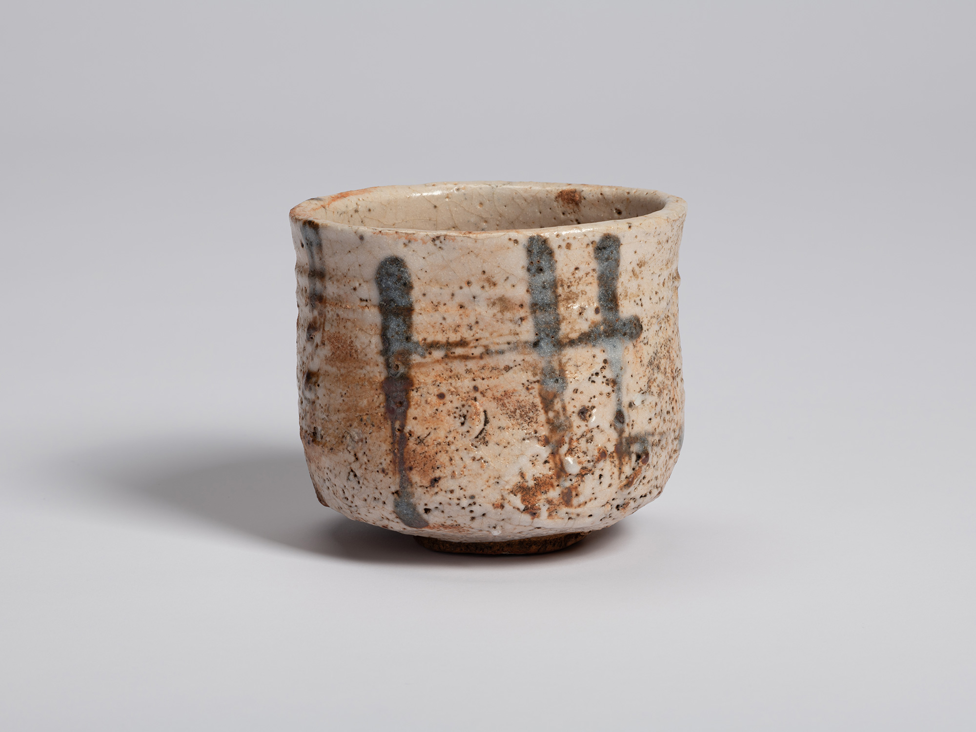 Front view of the Shino Chawan highlighting a broad area of creamy glaze accented by gray brushwork...