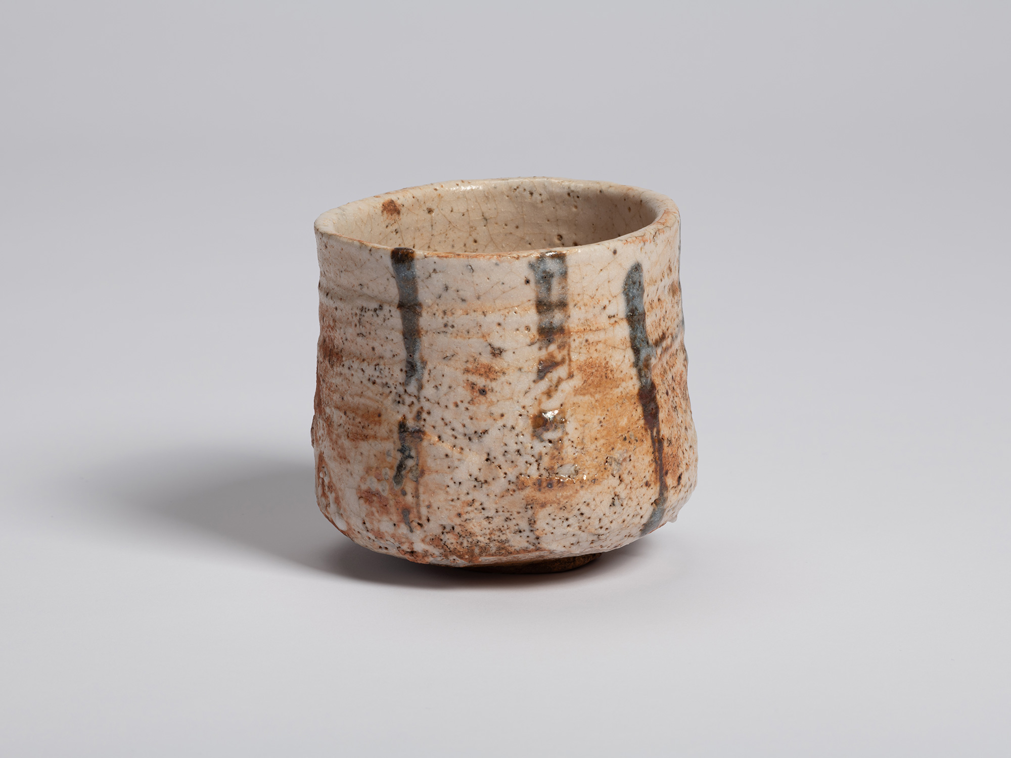 View of a Shino Chawan by Shiro Tsujimura. The cylindrical tea bowl is covered in a creamy white...