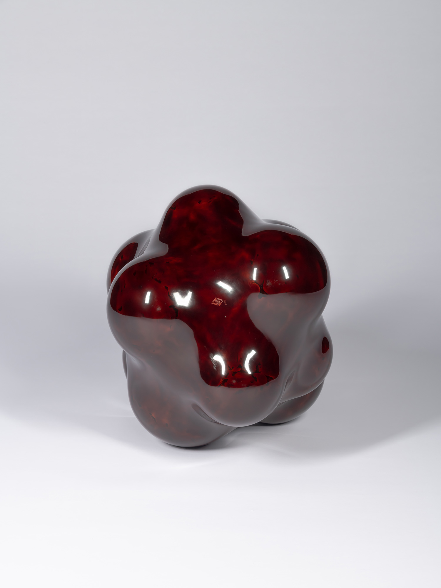 Bottom view of Surface Tactility #17. The underside reveals a broad crimson-red field framed by...