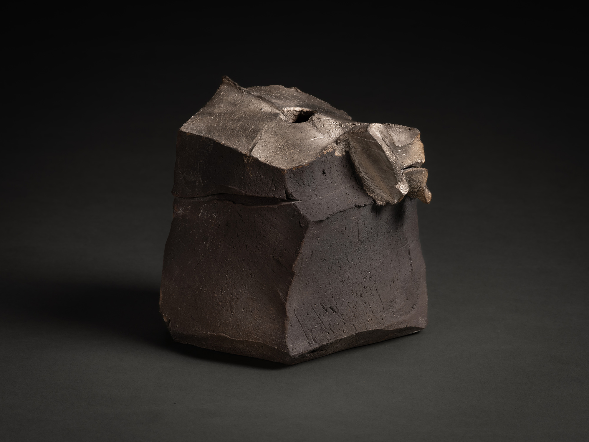 View of Tanka Silver Sculpture by Shozo Michikawa. The compact, dark stoneware form has faceted...