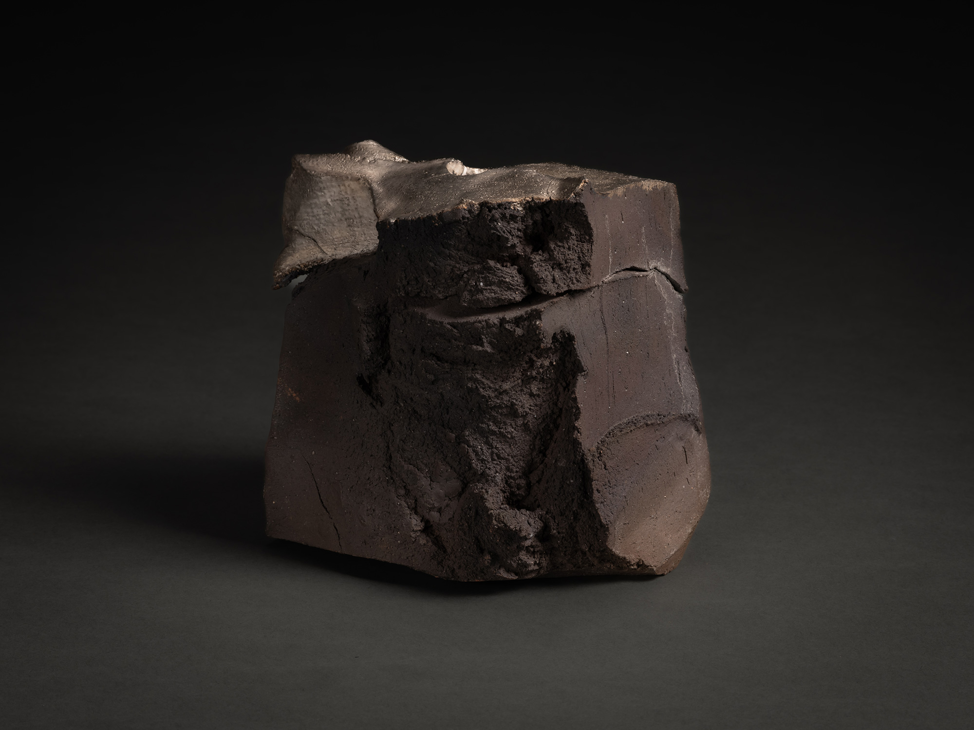 View of Tanka Silver Sculpture showing a coarse, unsmoothed vertical section of exposed clay running...