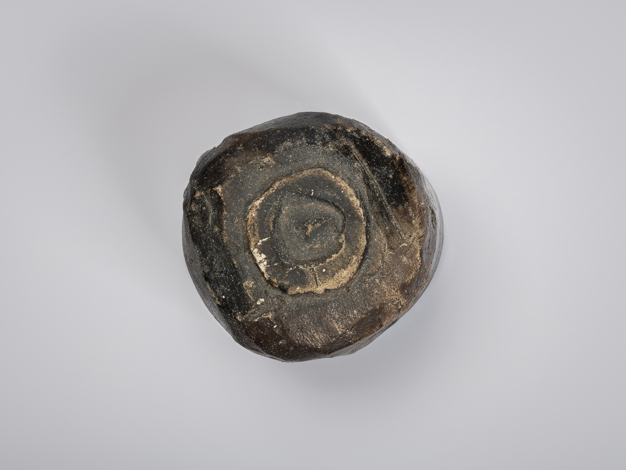 Underside view of a hikidashi-type tea bowl by Shiro Tsujimura. The base features a small, circular...