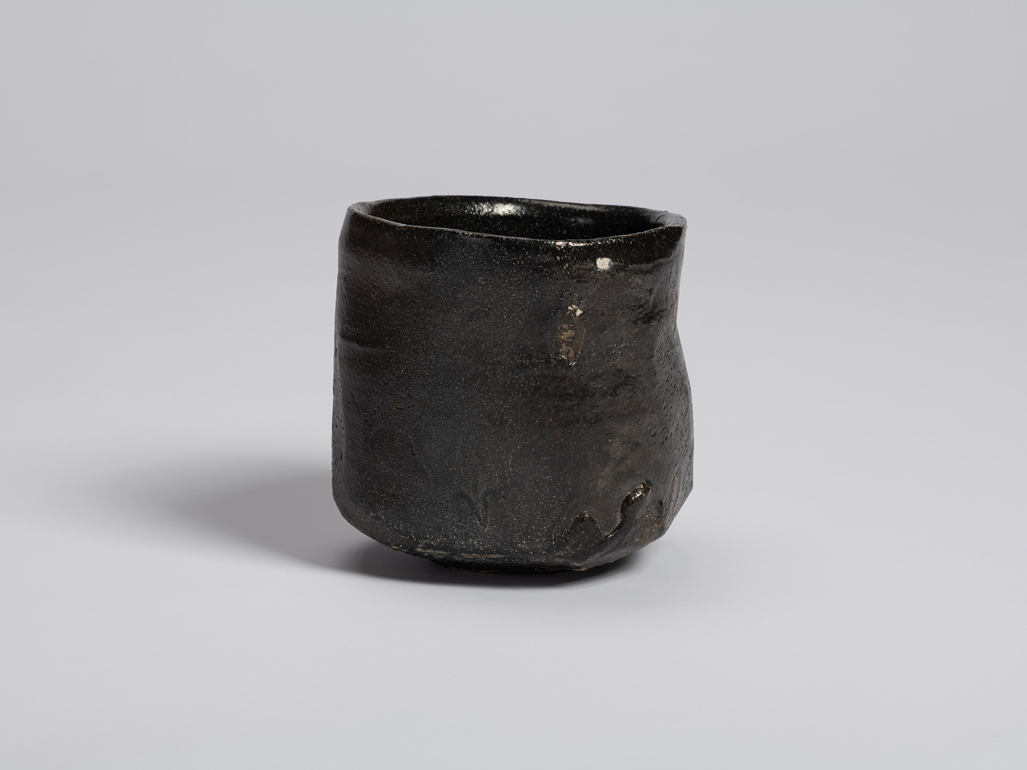 Hikidashi-type tea bowl by Shiro Tsujimura. The cylindrical form is covered in a deep black surface...