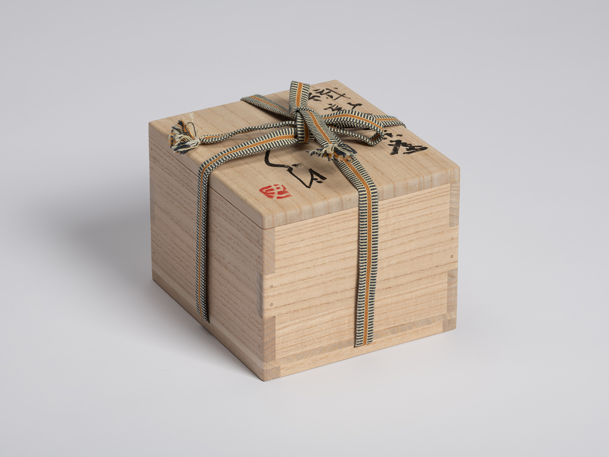 View of a closed paulownia wood tomobako for a tea bowl by Shiro Tsujimura. The box is secured...