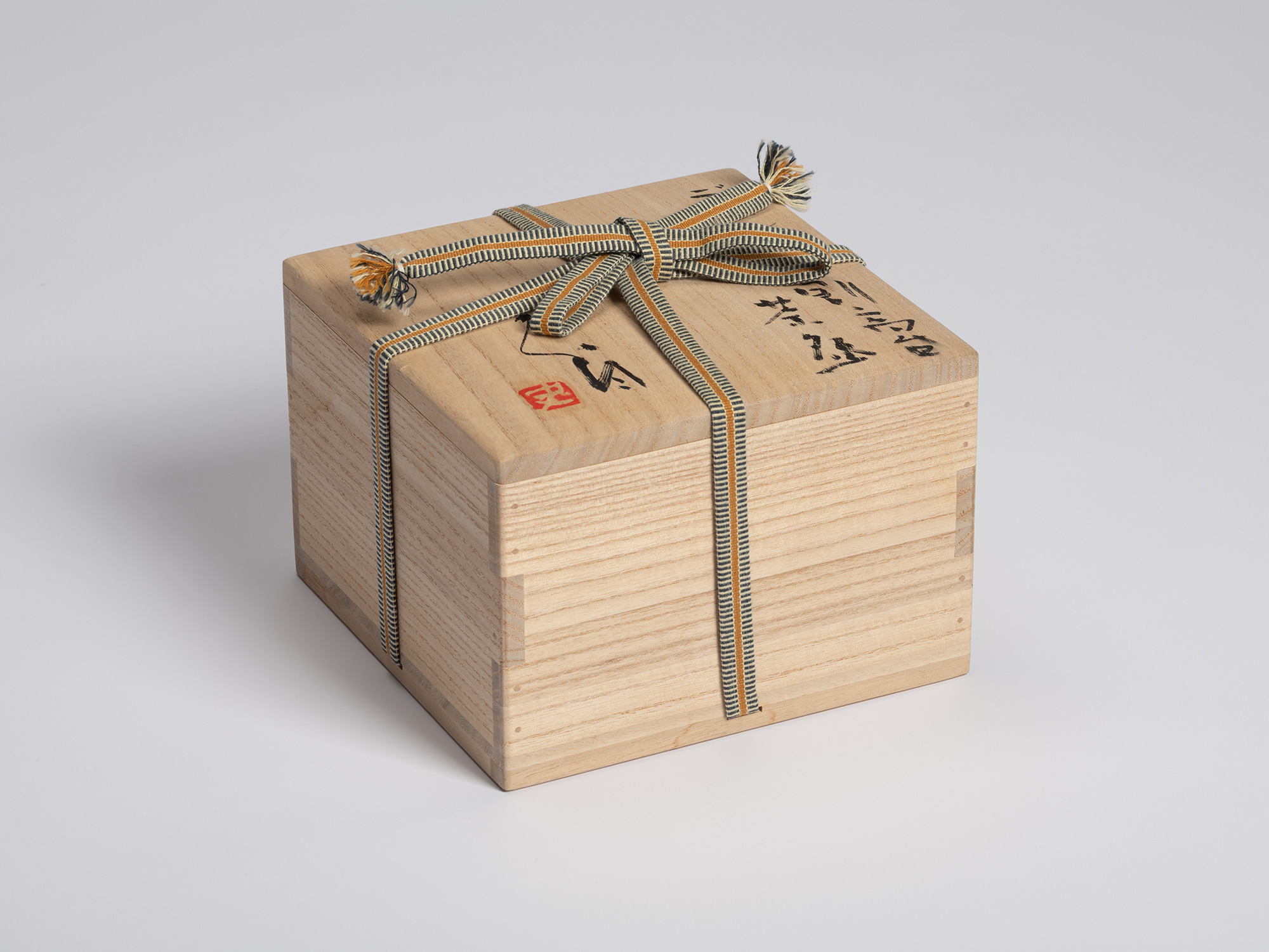 Tomobako for Tea Bowl (Tripodal Foot) by Shiro Tsujimura. The kiri wood box displays bold black...