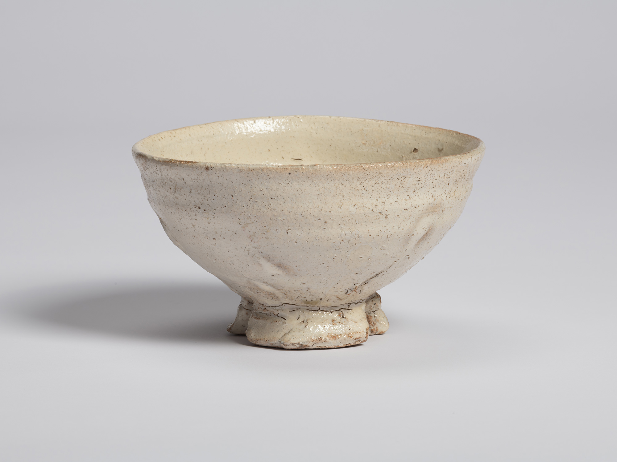 View of a tea bowl with a tripodal foot by Shiro Tsujimura. The bowl has a wide, gently flared...